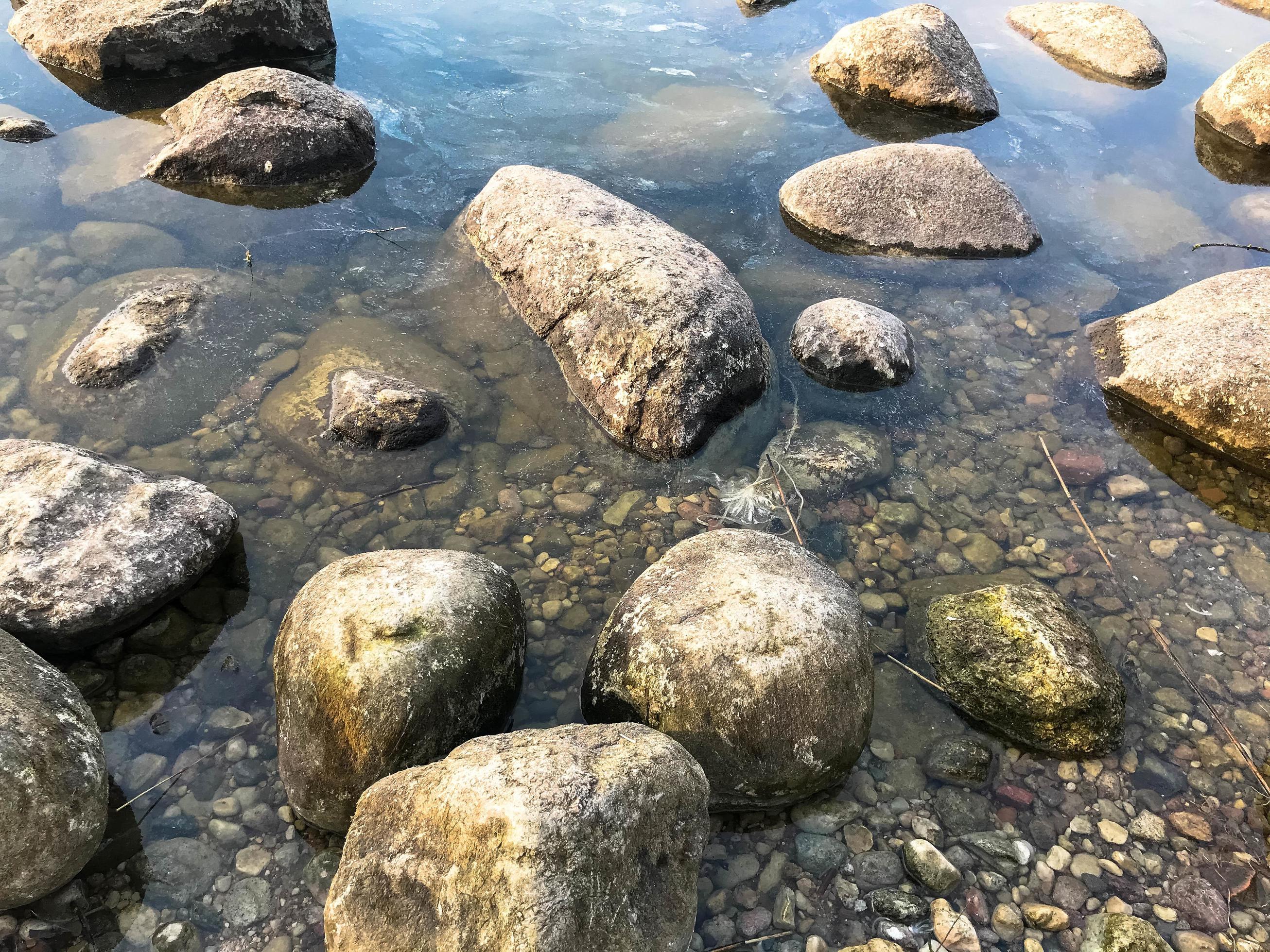 Large round beautiful natural stones cobblestones in water, sea, lake, river. Background, texture Stock Free