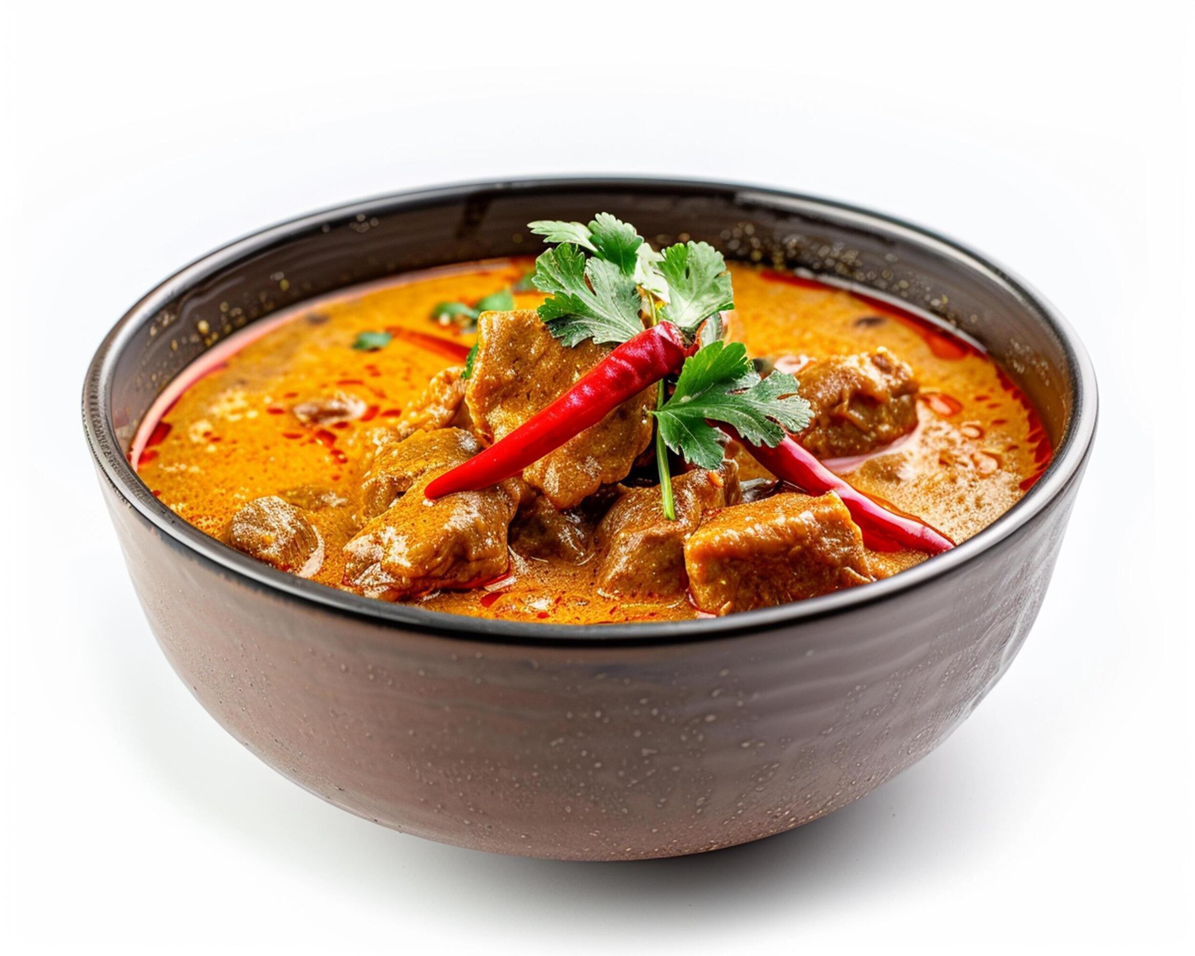 a bowl of curry with meat and herbs Stock Free