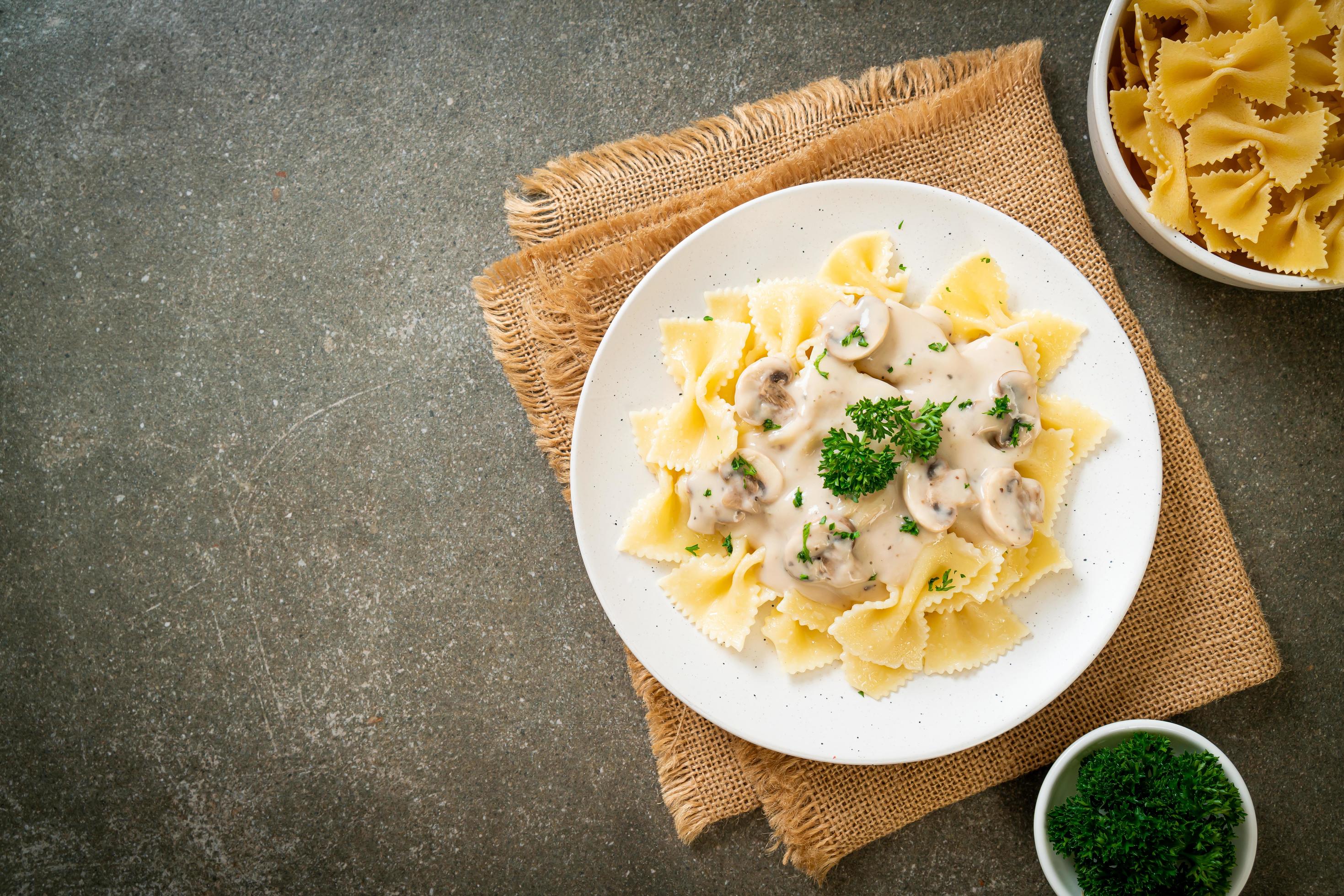 Farfalle pasta with mushroom white cream sauce – Italian food style Stock Free