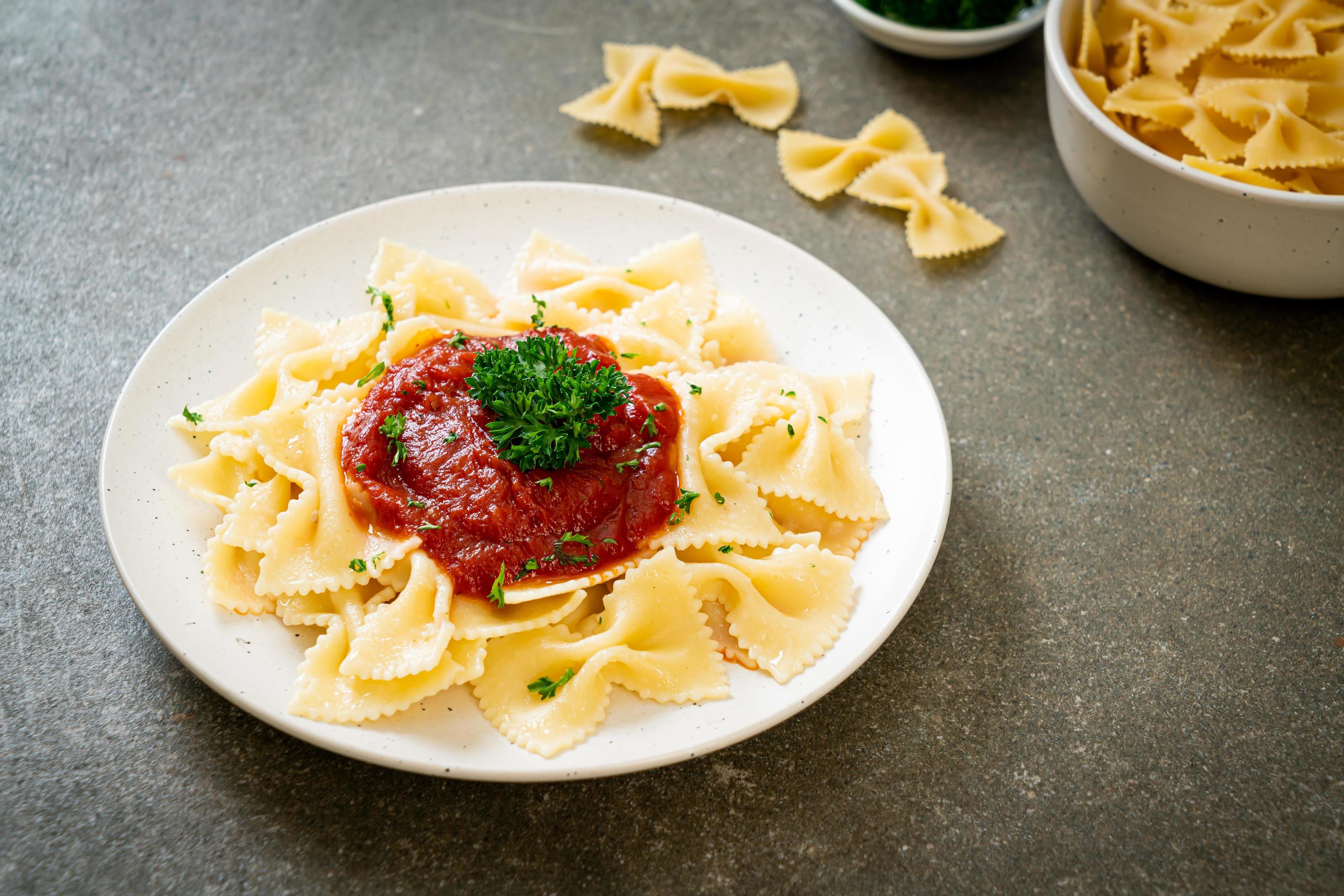 Farfalle pasta in tomato sauce with parsley – Italian food style Stock Free