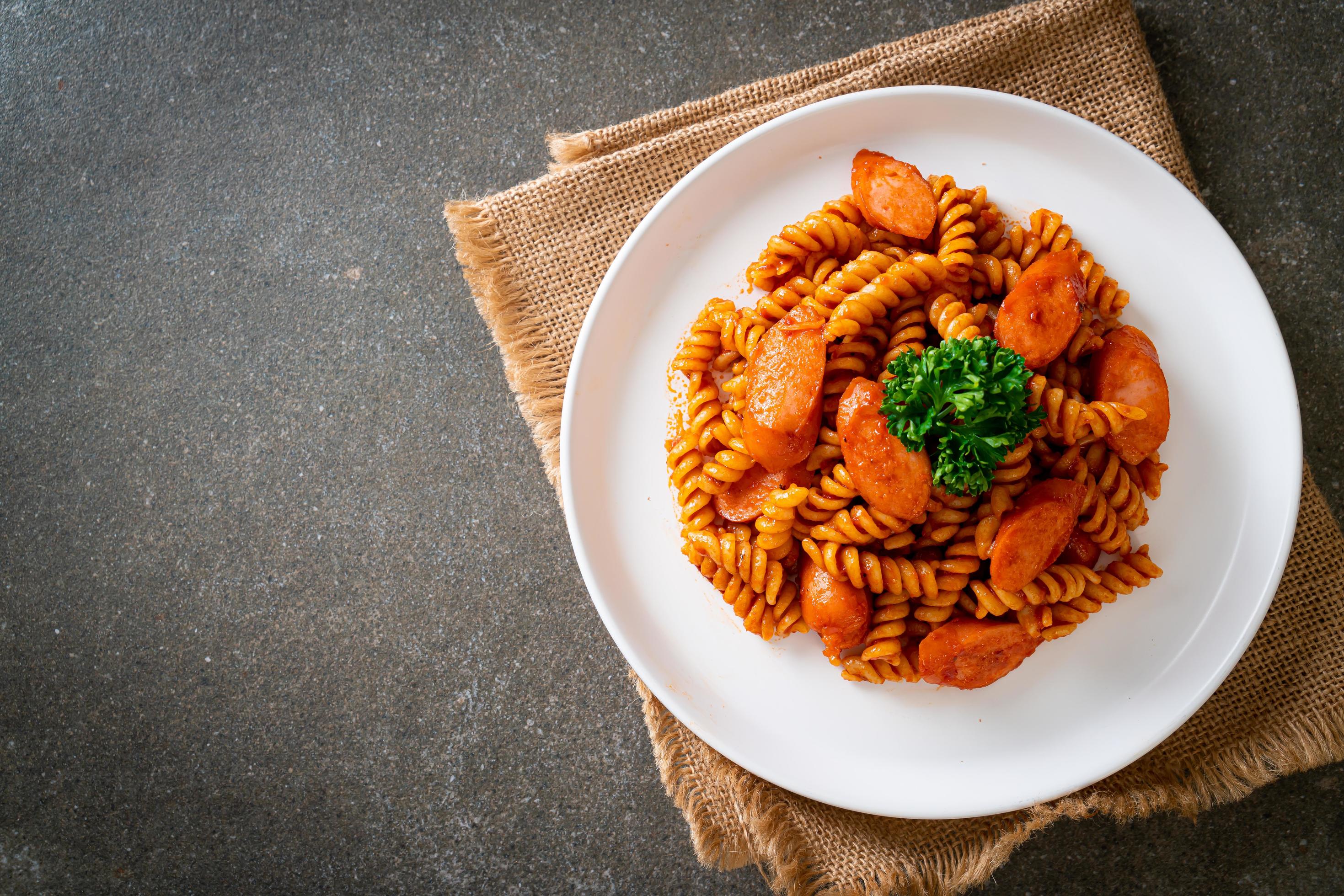 Spiral or spirali pasta with tomato sauce and sausage – Italian food style Stock Free