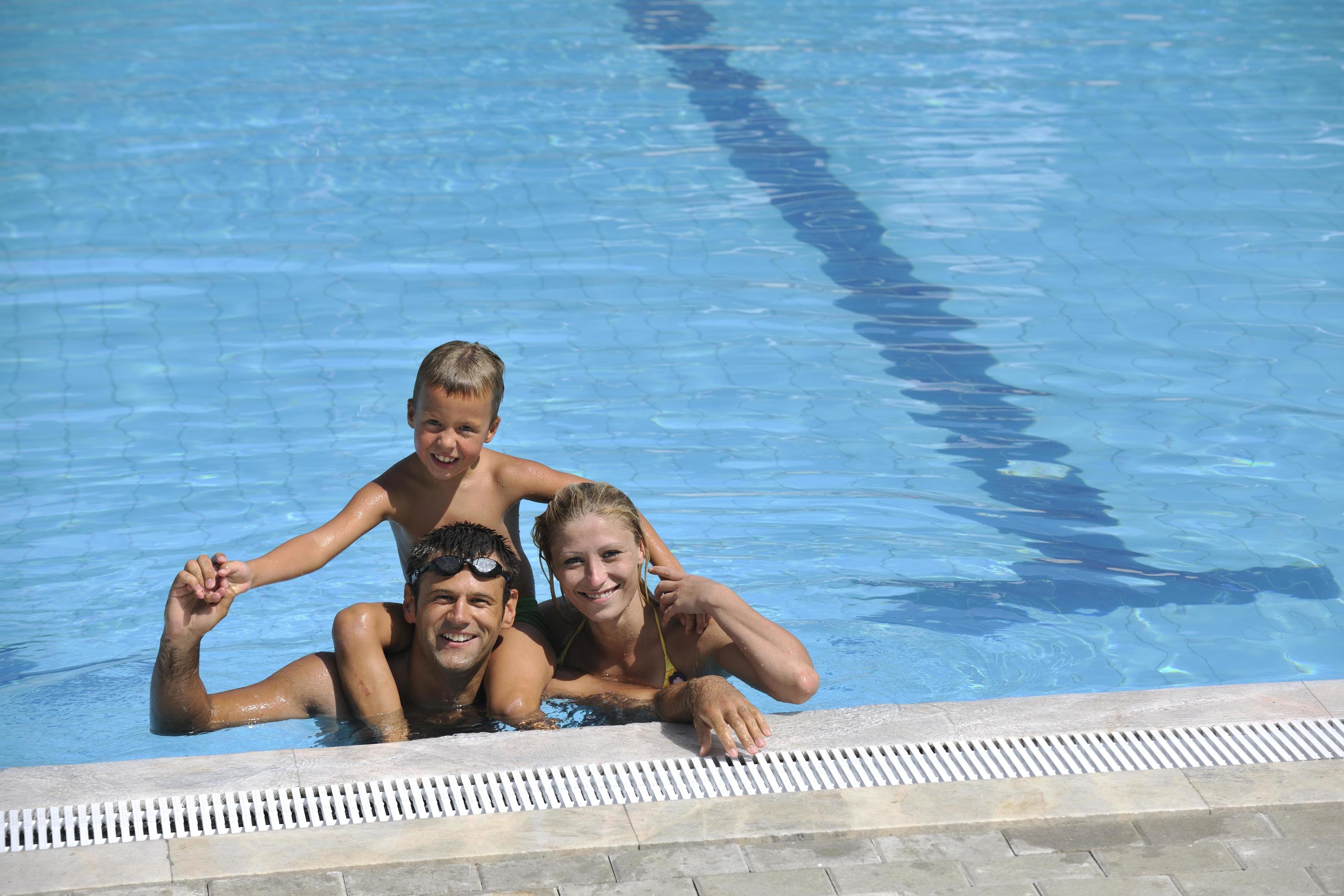 happy young family have fun on swimming pool Stock Free