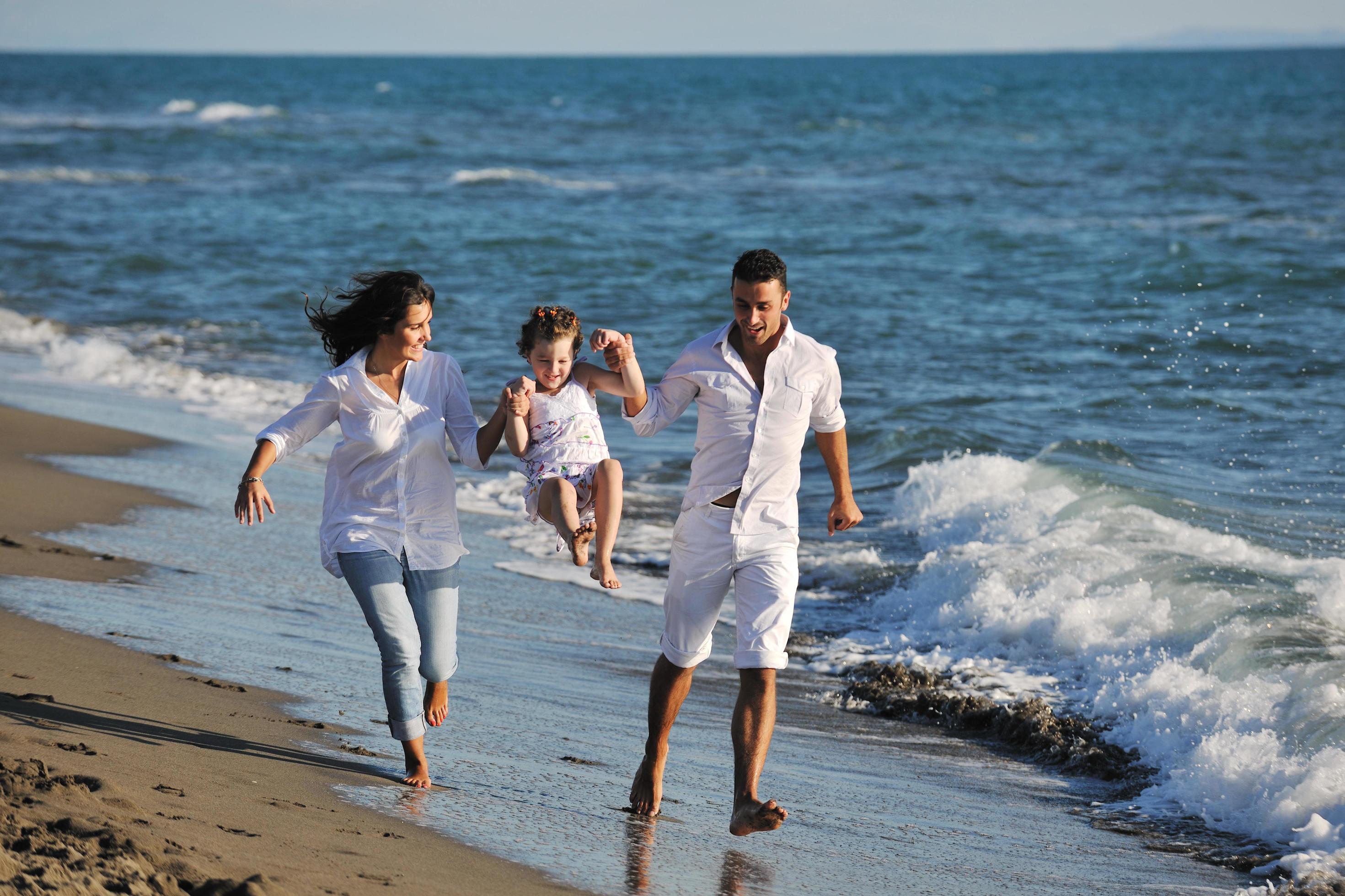 happy young family have fun on beach Stock Free