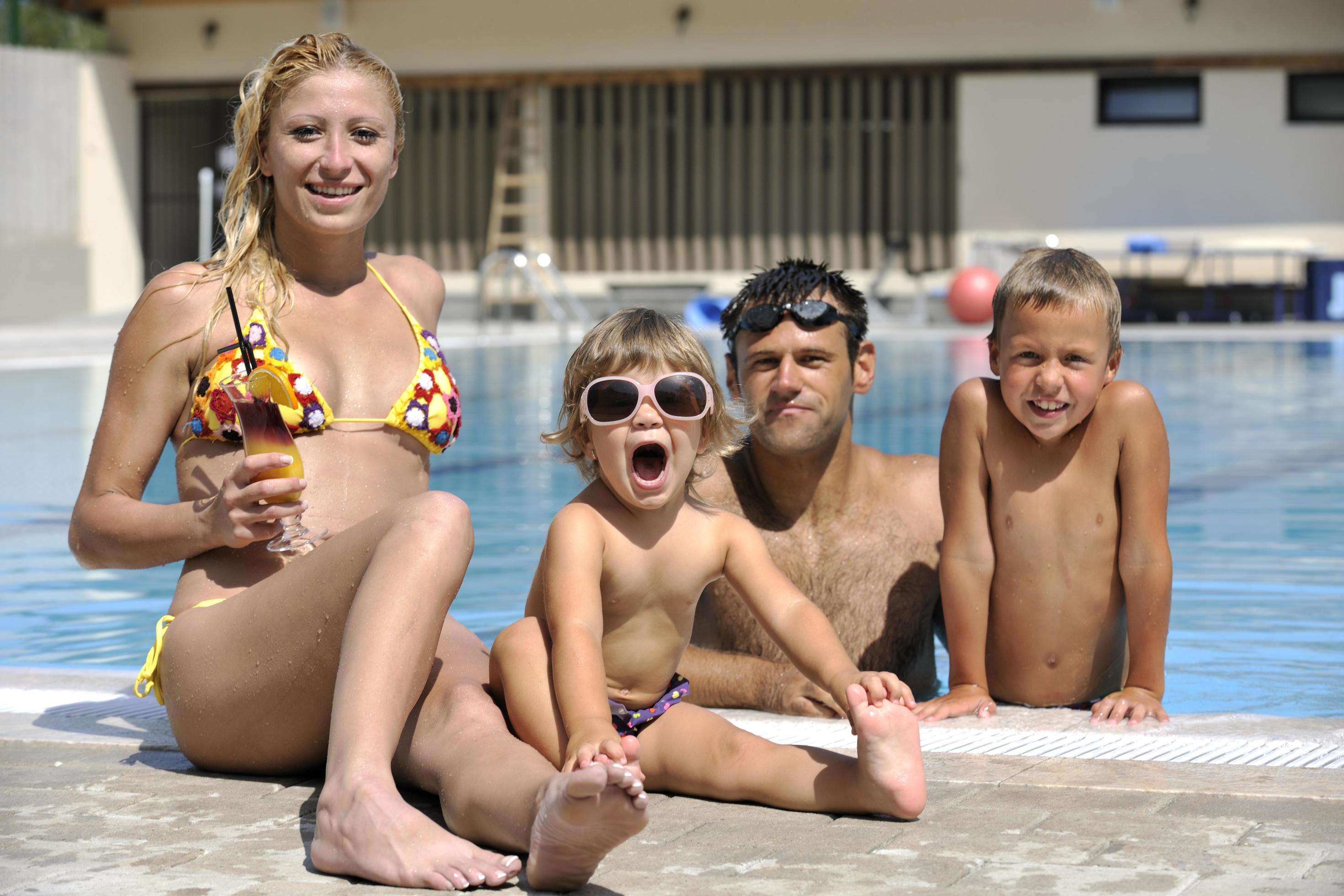 happy young family have fun on swimming pool Stock Free