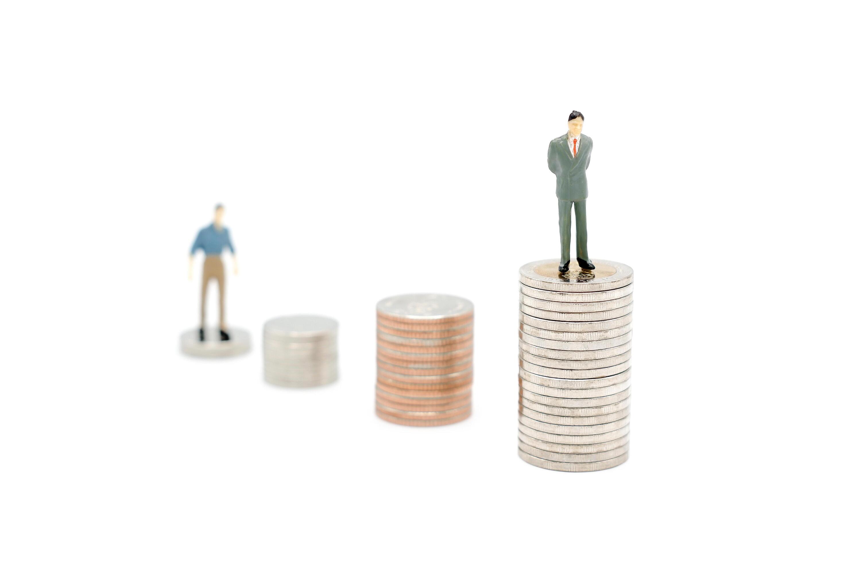 Two miniature people walking and standing on pile of new Thai Baht coins, isolated on white background. Business and finance concept. Stock Free