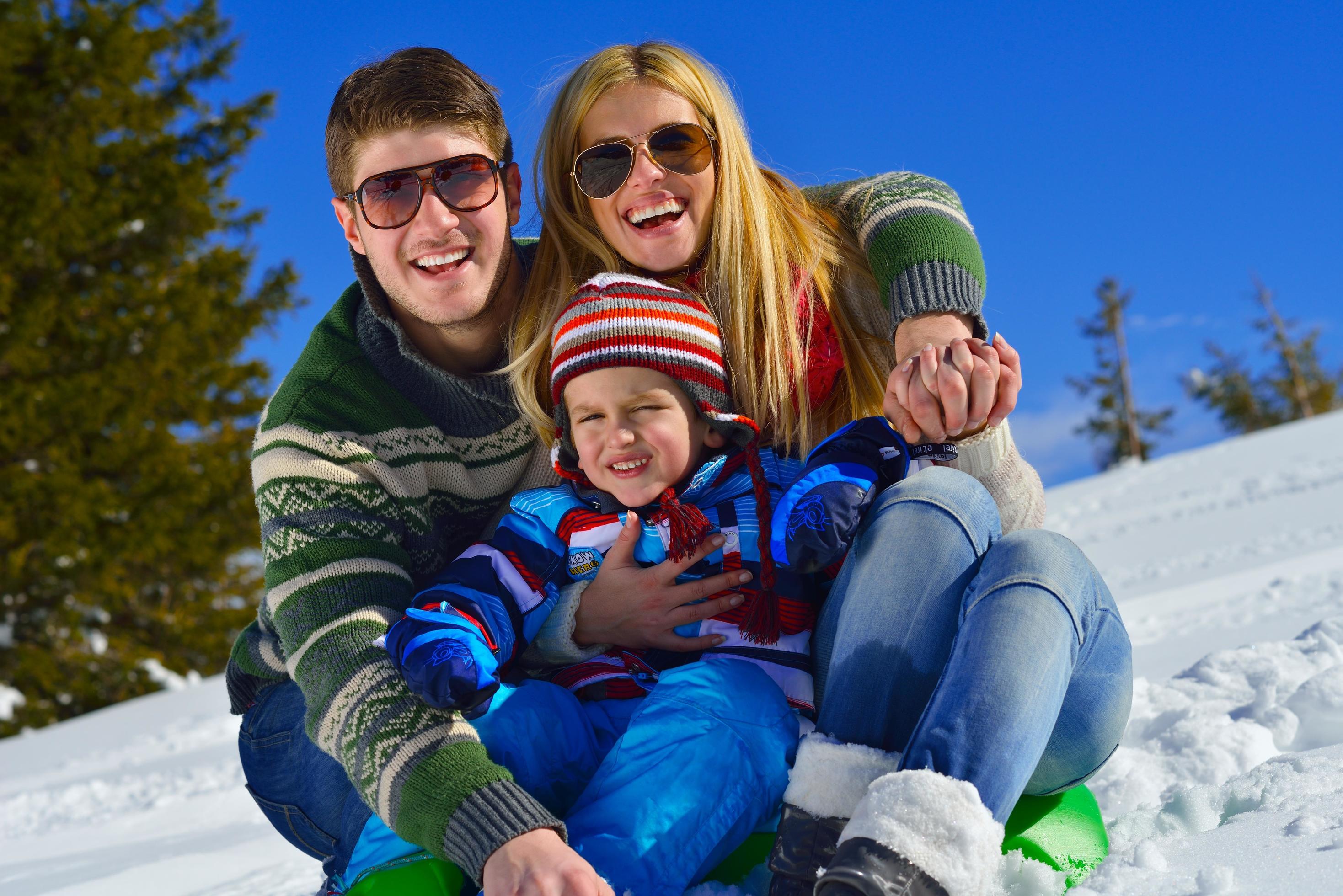 family having fun on fresh snow at winter vacation Stock Free