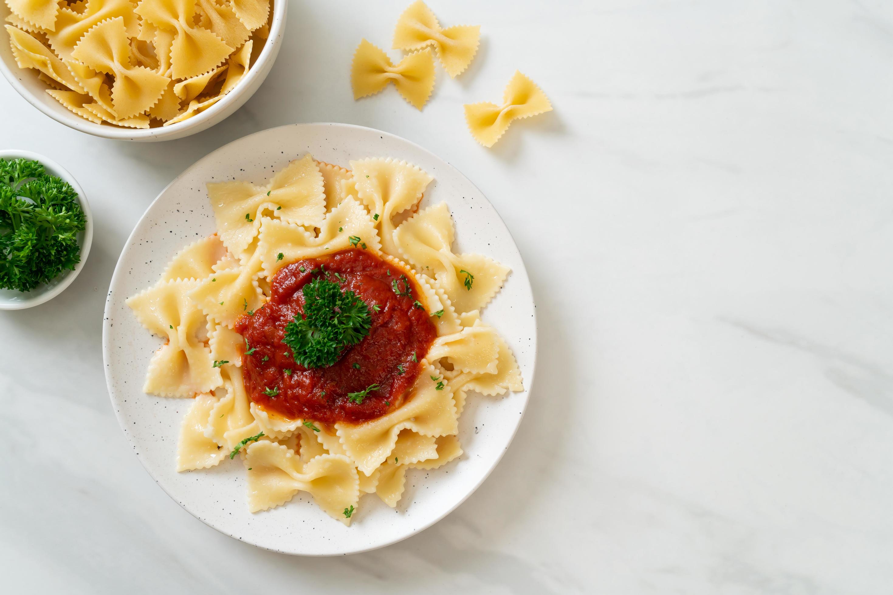 Farfalle pasta in tomato sauce with parsley – Italian food style Stock Free