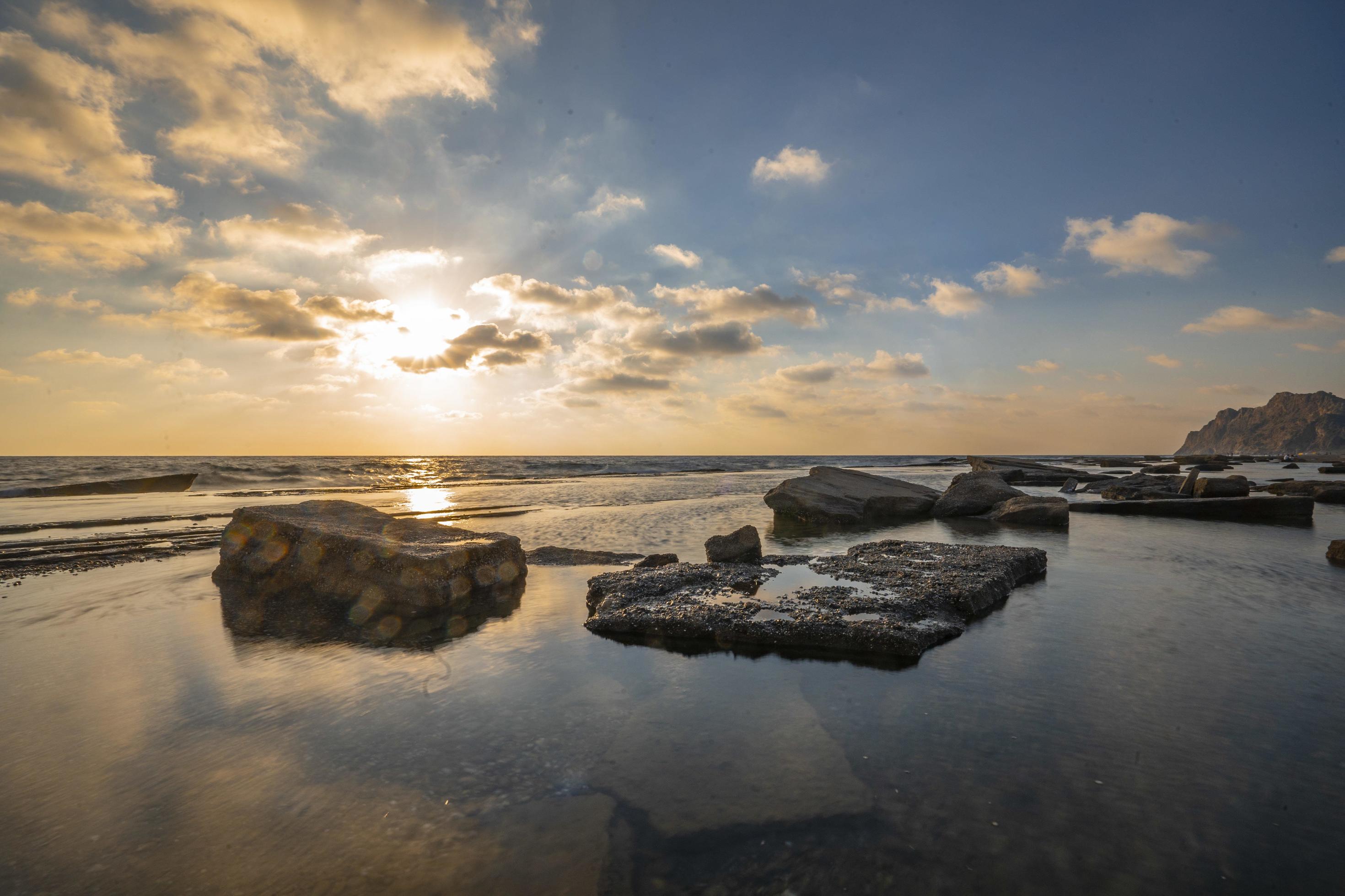 Long exposure photography of waves and pebbles on Beach in the sunset Stock Free