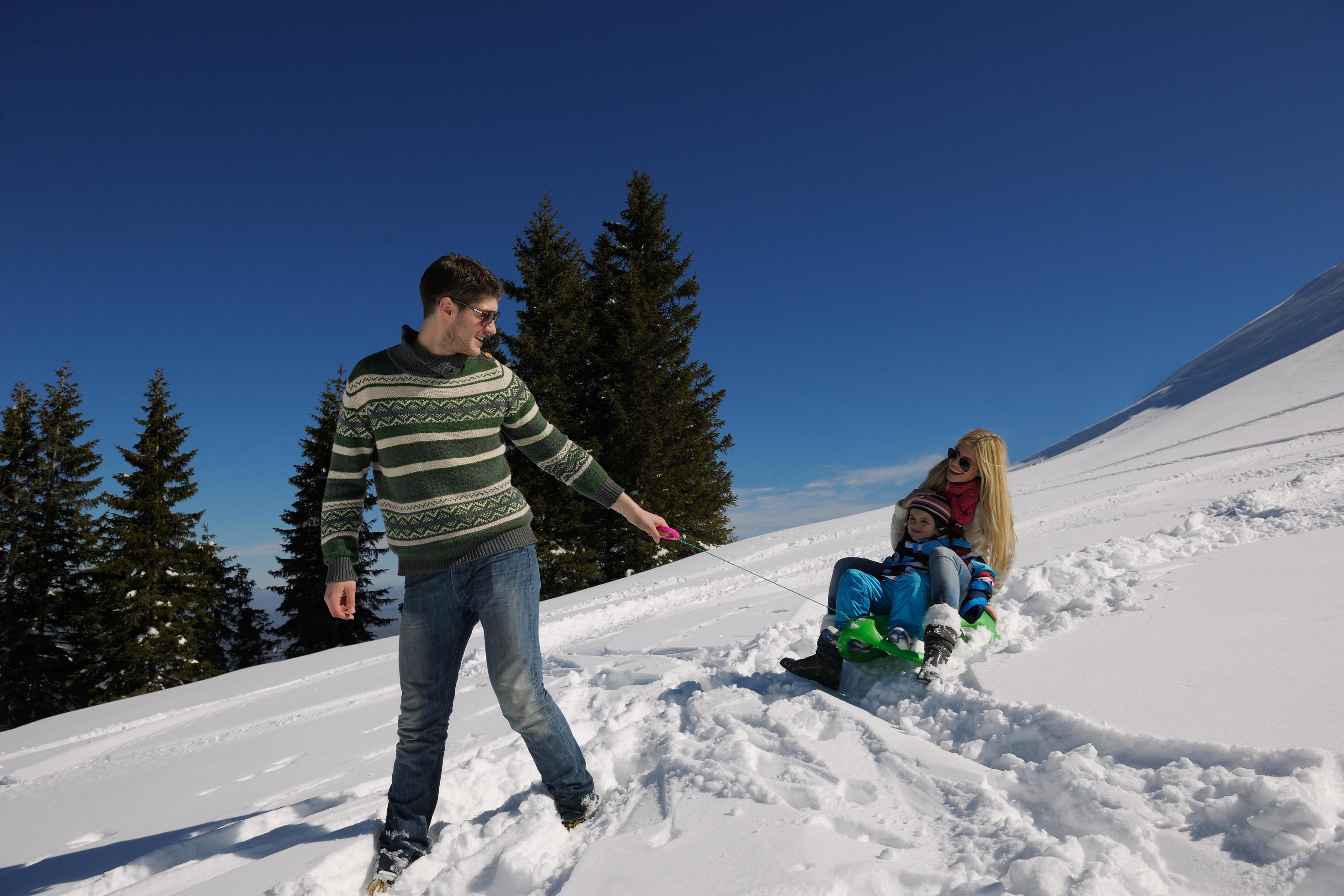 family having fun on fresh snow at winter vacation Stock Free