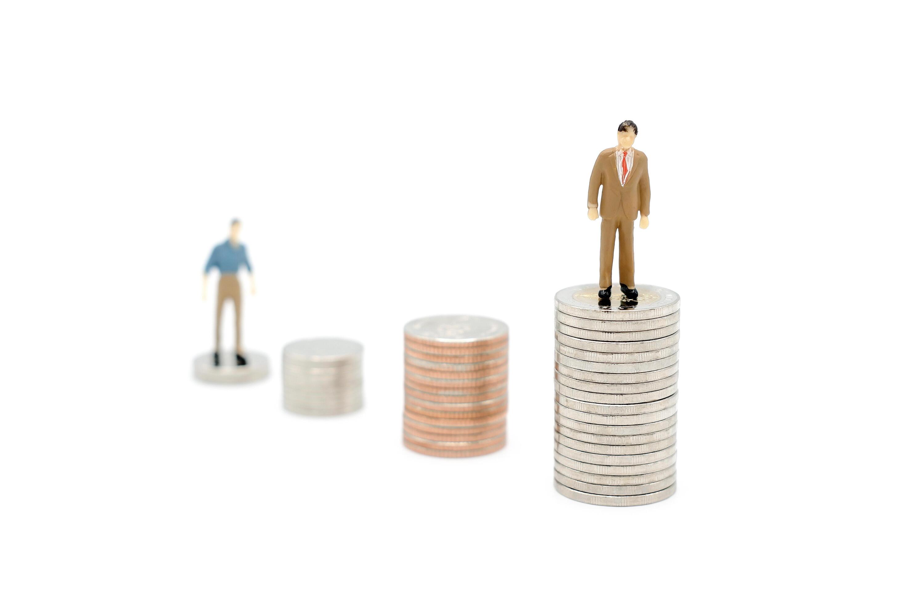 Two miniature people walking and standing on pile of new Thai Baht coins, isolated on white background. Business and finance concept. Stock Free