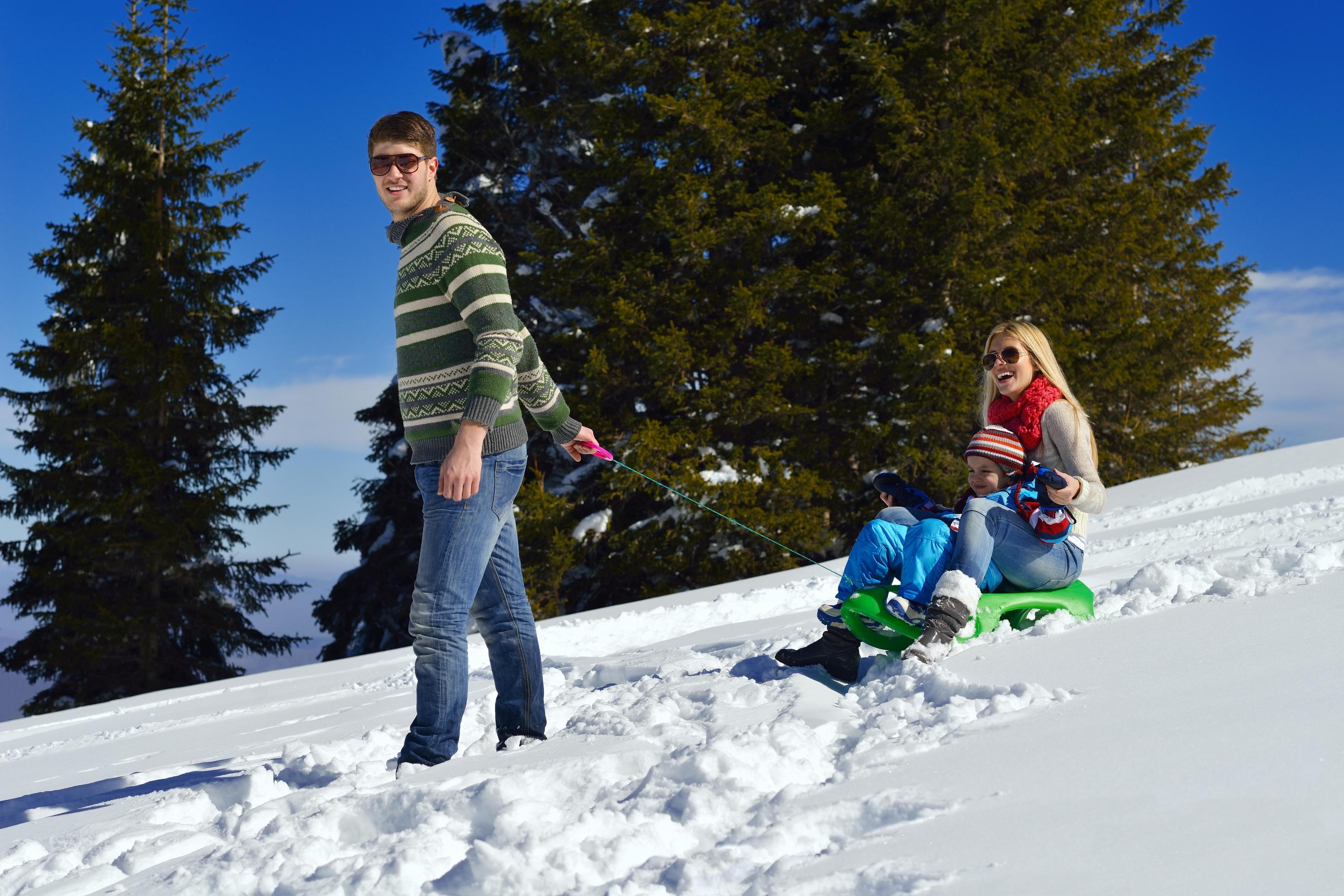 family having fun on fresh snow at winter vacation Stock Free