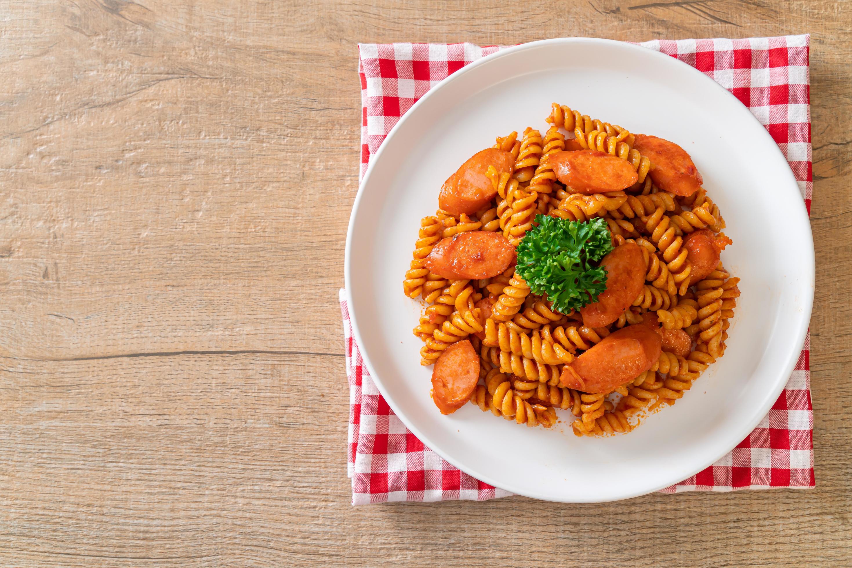 Spiral or spirali pasta with tomato sauce and sausage – Italian food style Stock Free