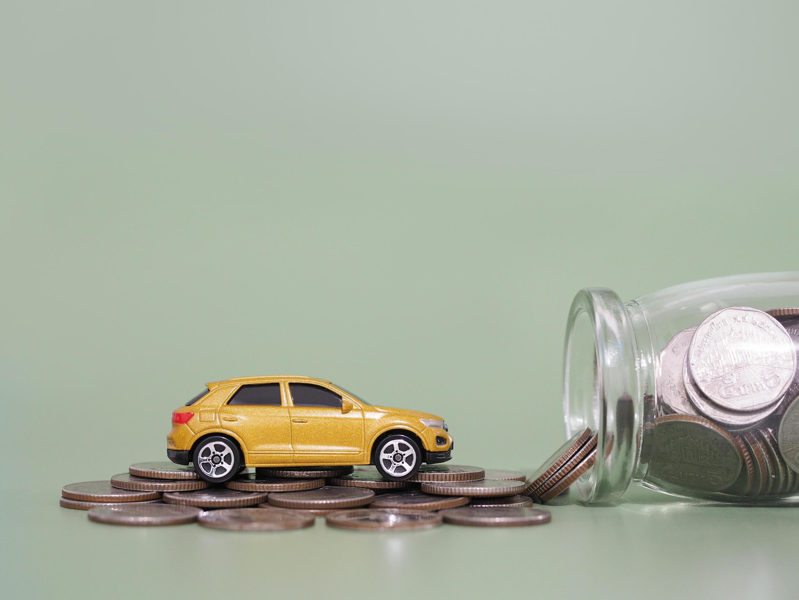 Toy car and stack of coins. The concept of saving money and manage to success transport business Stock Free