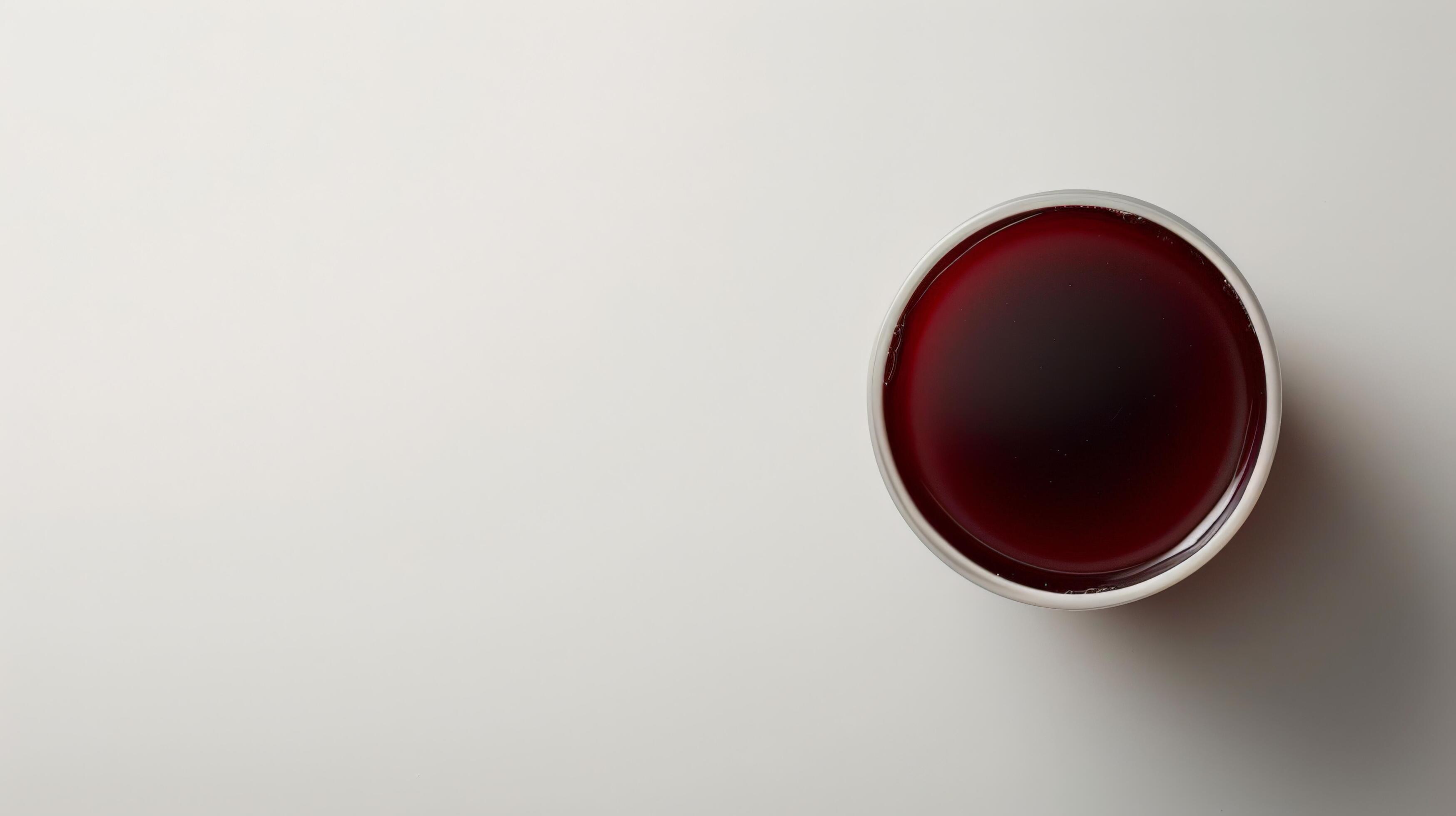 A glass of prune juice sits on a white background Stock Free