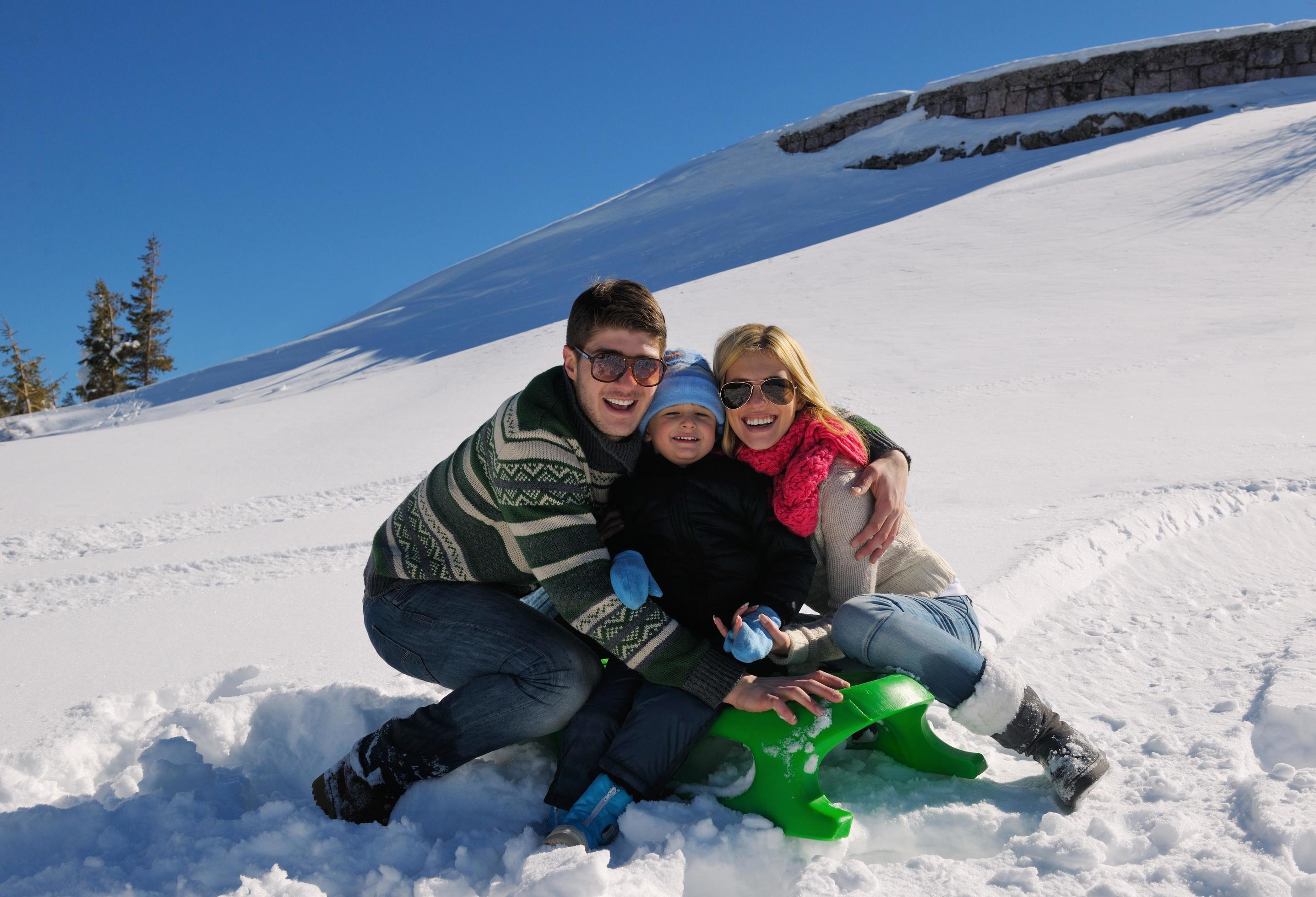 family having fun on fresh snow at winter vacation Stock Free