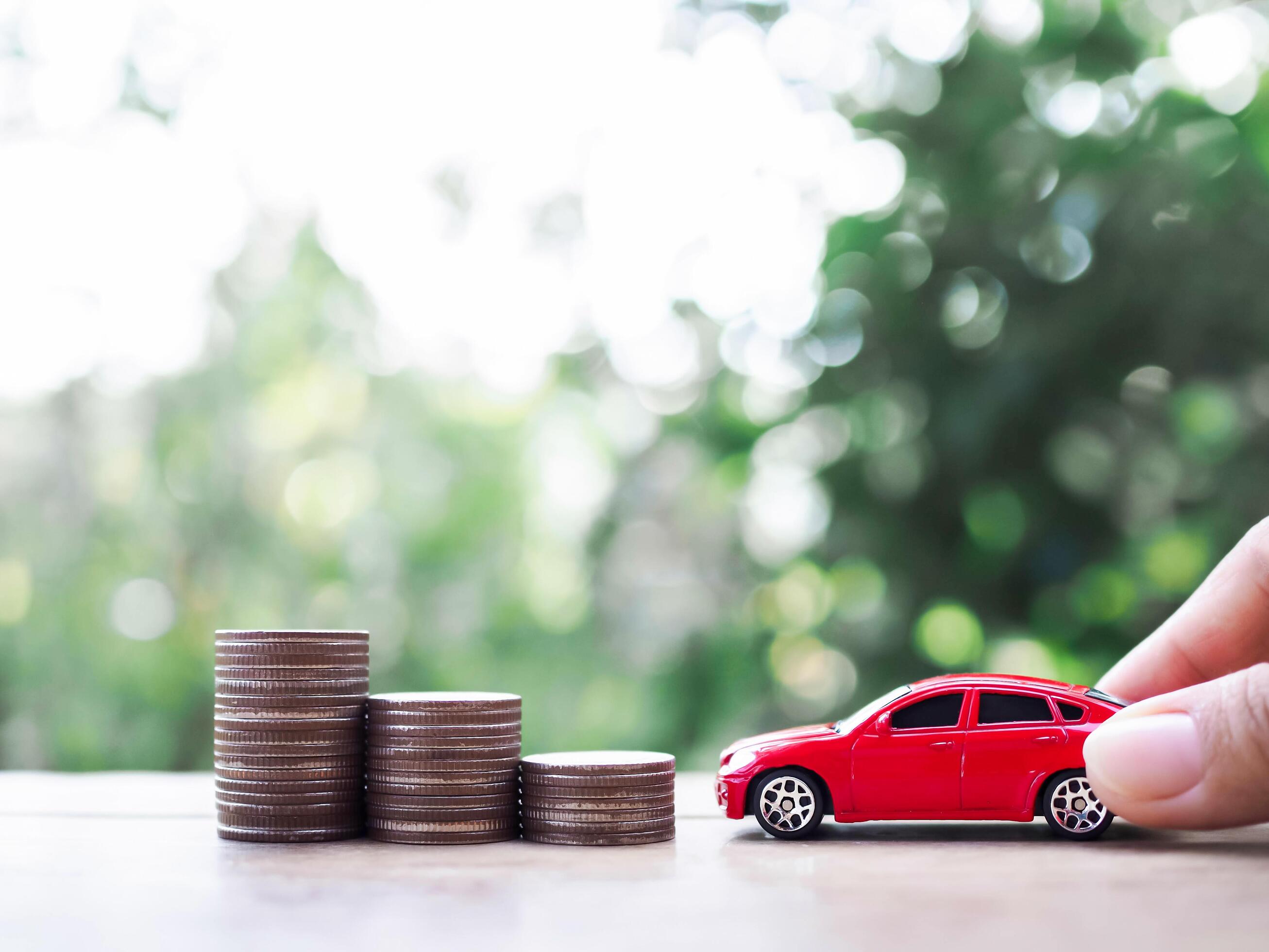 Toy cars and stack of coins. The concept of saving money and manage to success transport business Stock Free