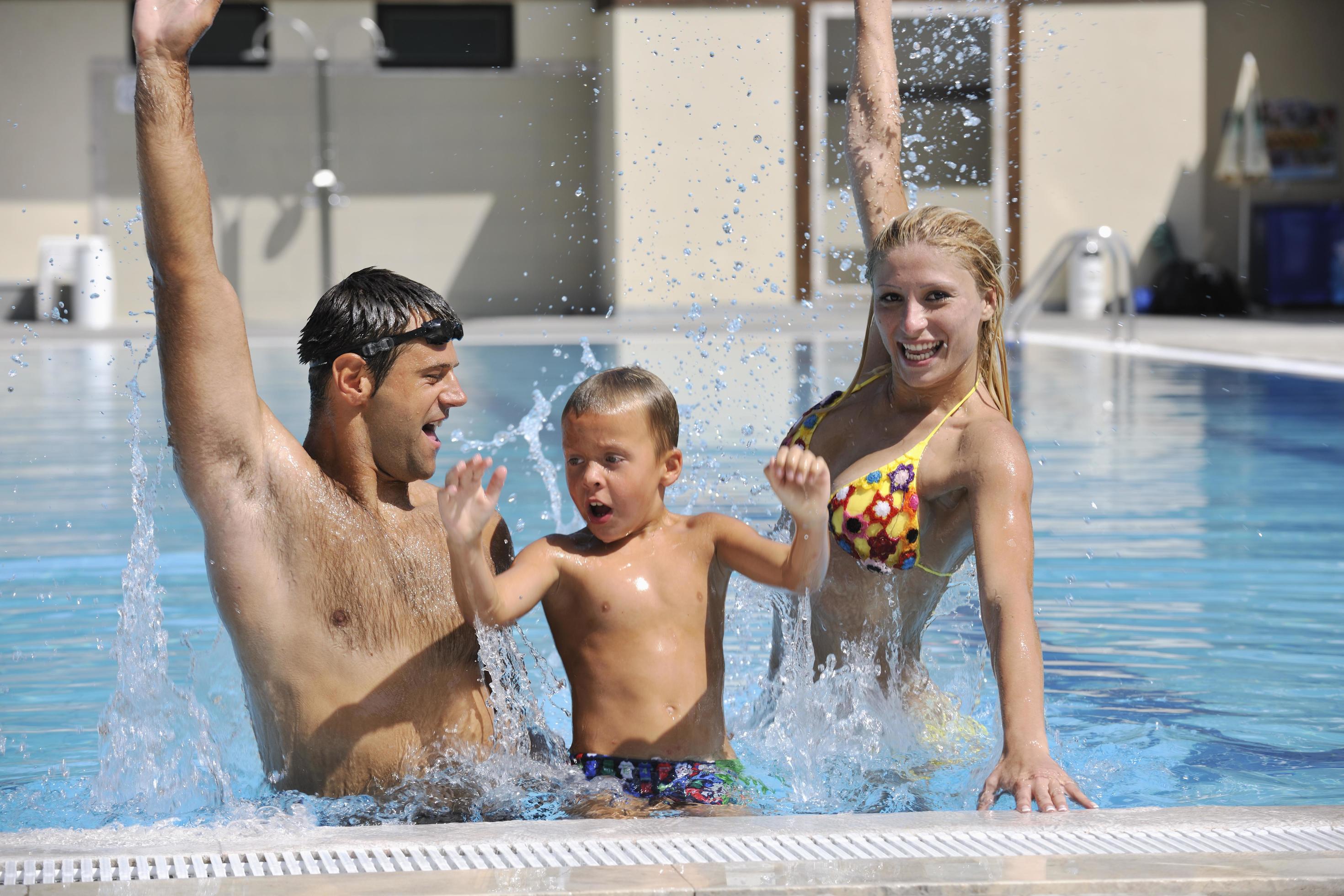 happy young family have fun on swimming pool Stock Free