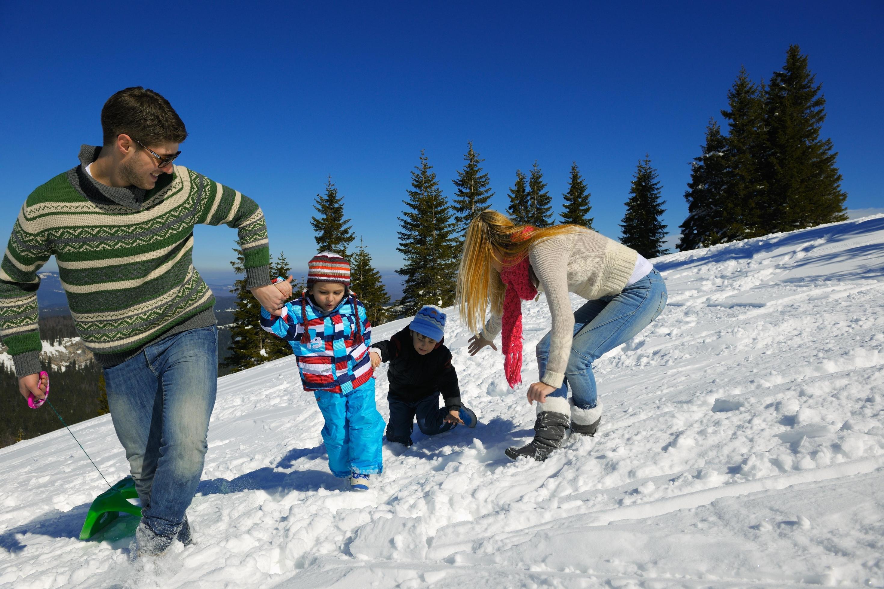 family having fun on fresh snow at winter vacation Stock Free