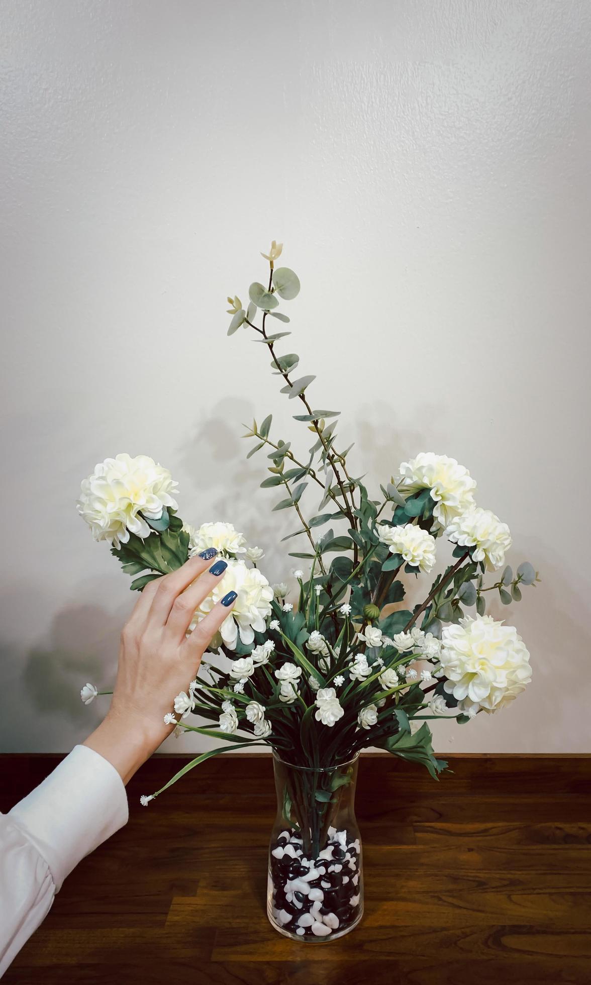 Beautiful hands of woman with dark manicure on nails with flower. Stock Free