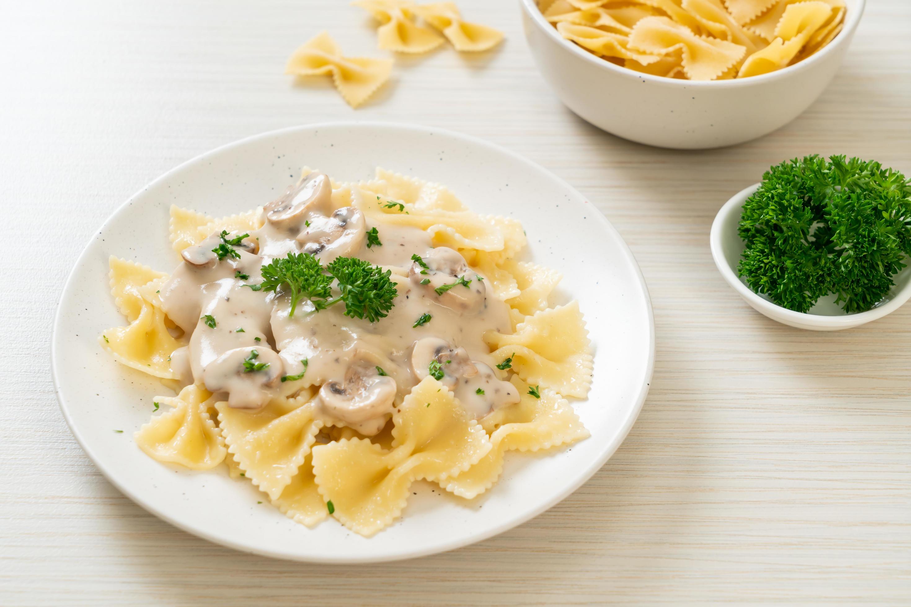 Farfalle pasta with mushroom white cream sauce – Italian food style Stock Free