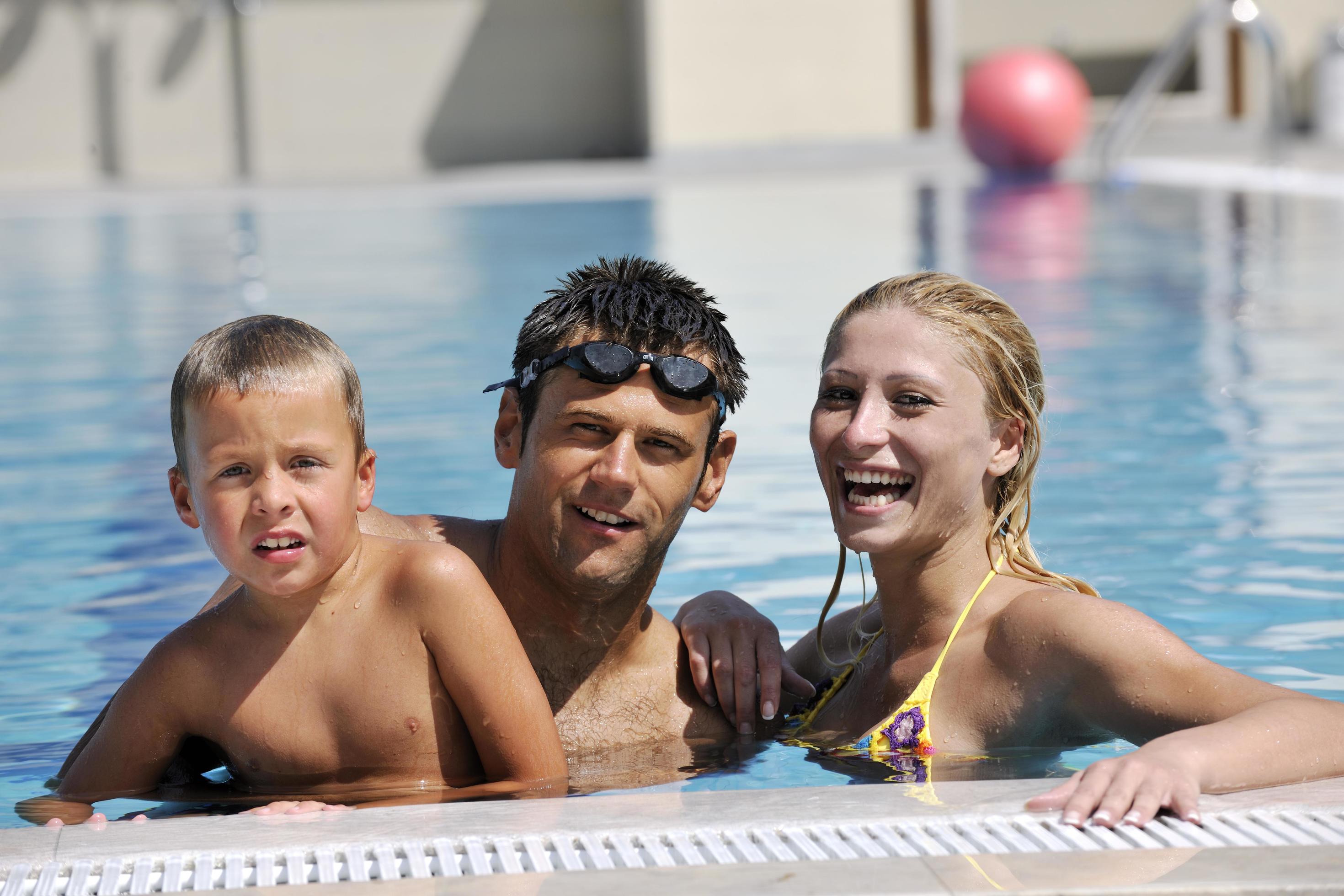 
									happy young family have fun on swimming pool Stock Free