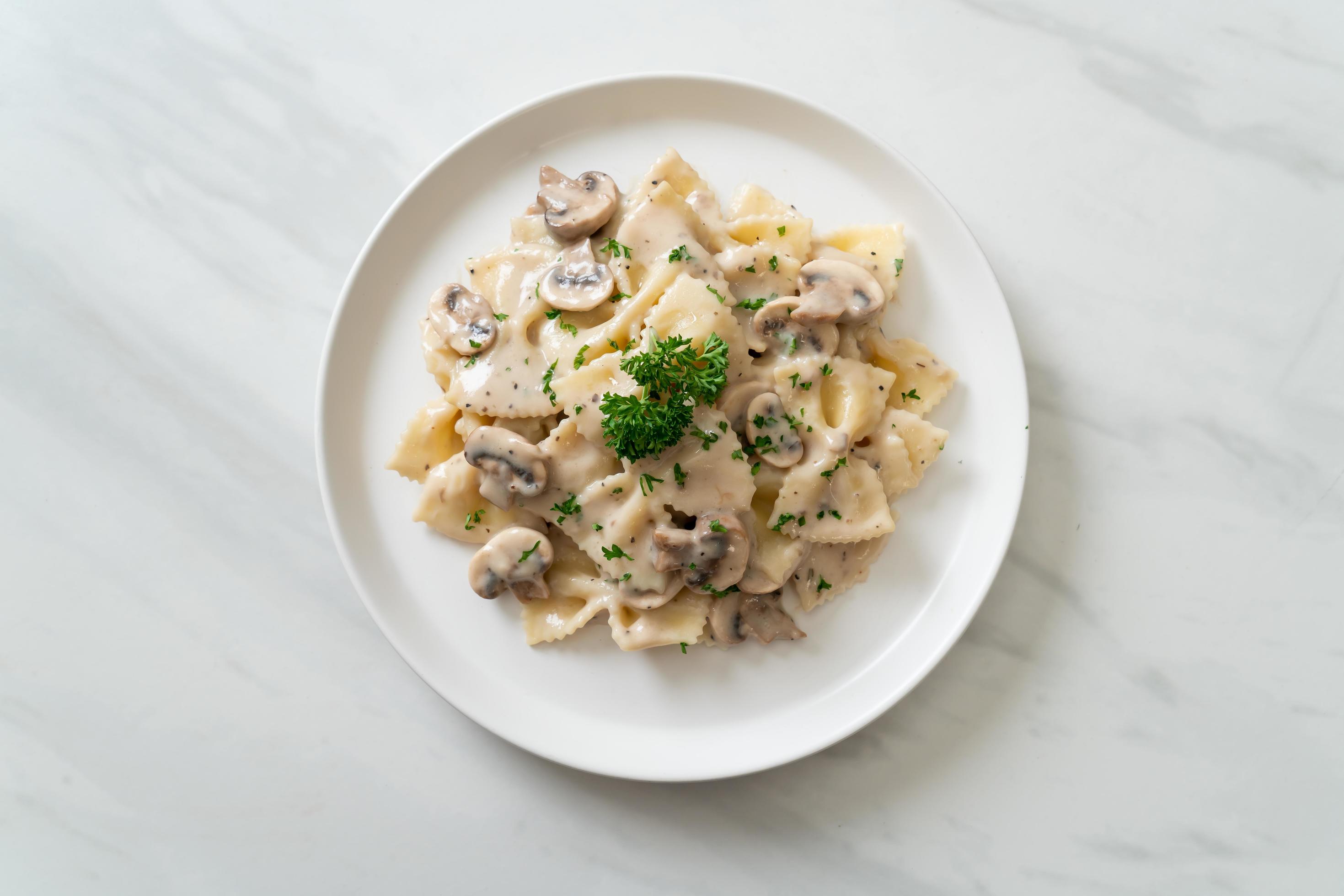 Farfalle pasta with mushroom white cream sauce – Italian food style Stock Free