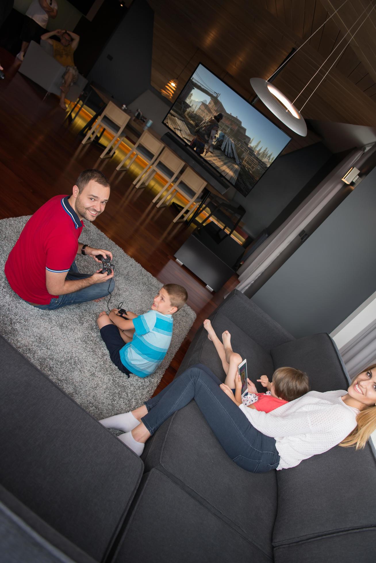 Happy family playing a third-person video game Stock Free