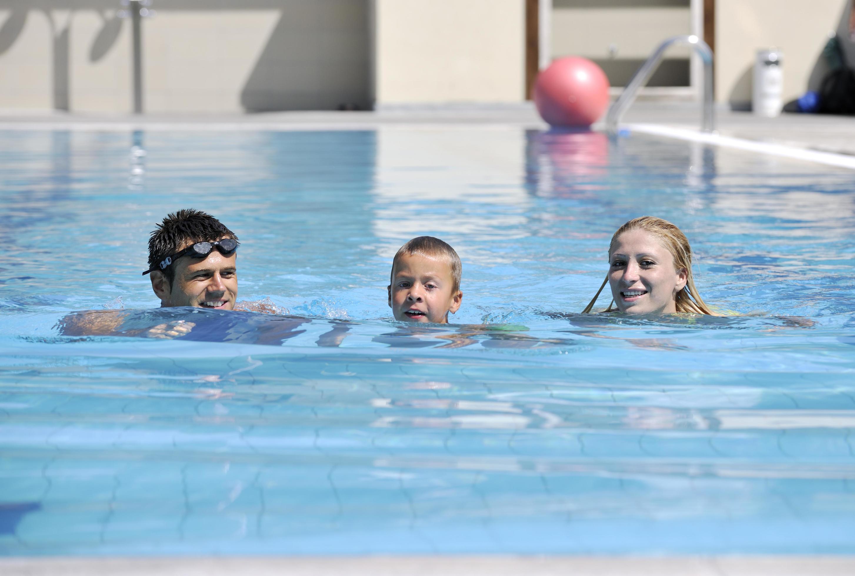 happy young family have fun on swimming pool Stock Free