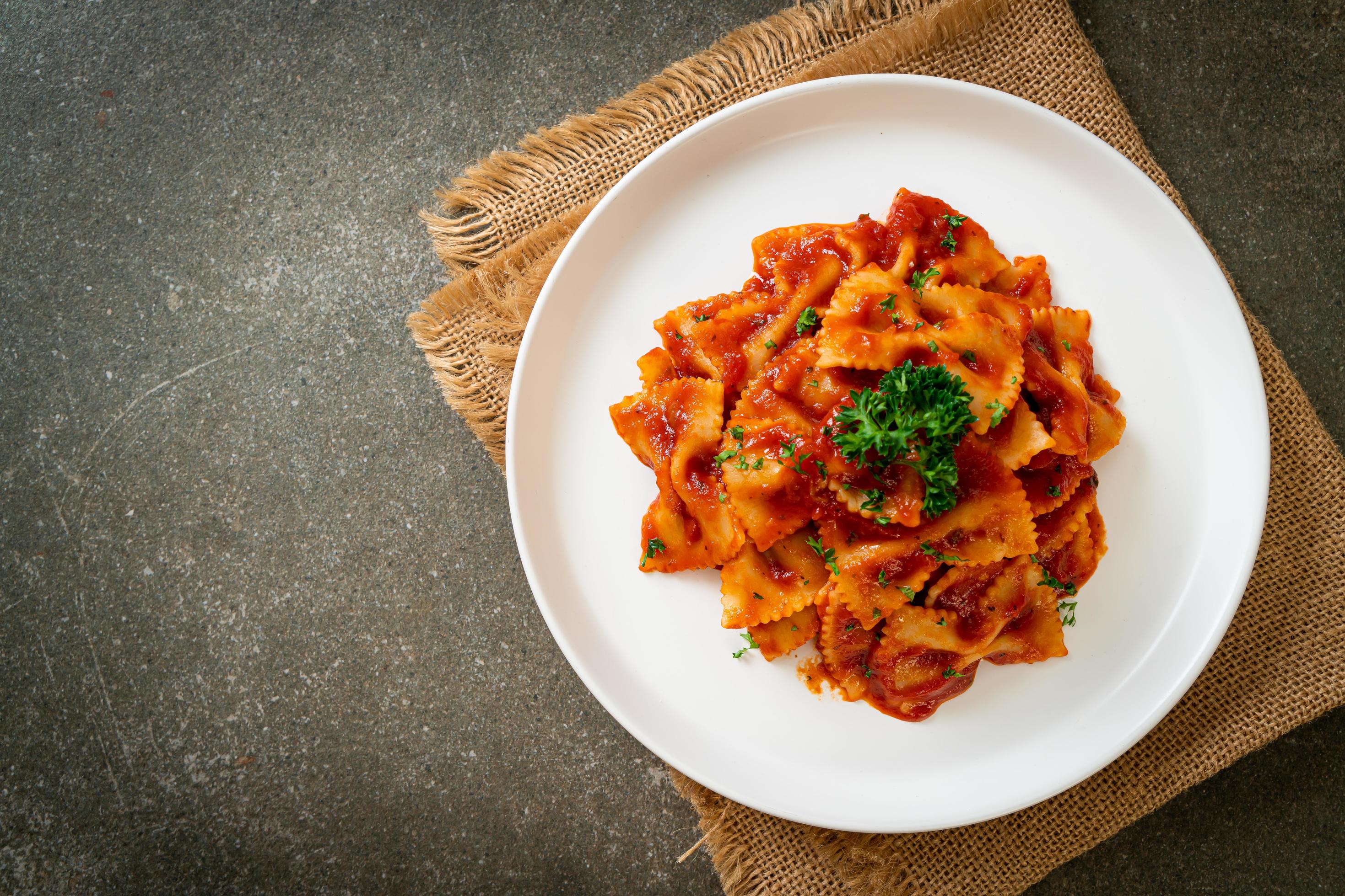 Farfalle pasta in tomato sauce with parsley – Italian food style Stock Free