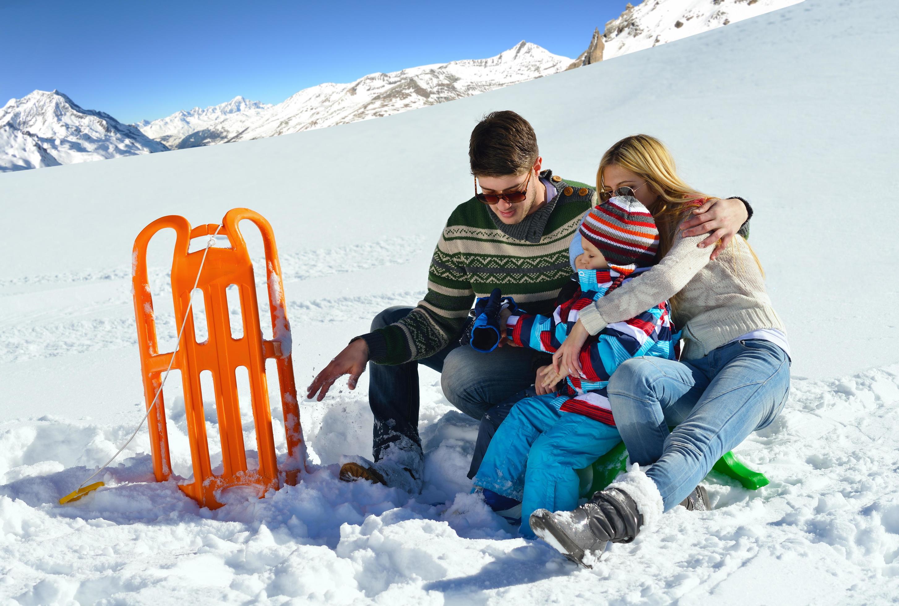 family having fun on fresh snow at winter vacation Stock Free