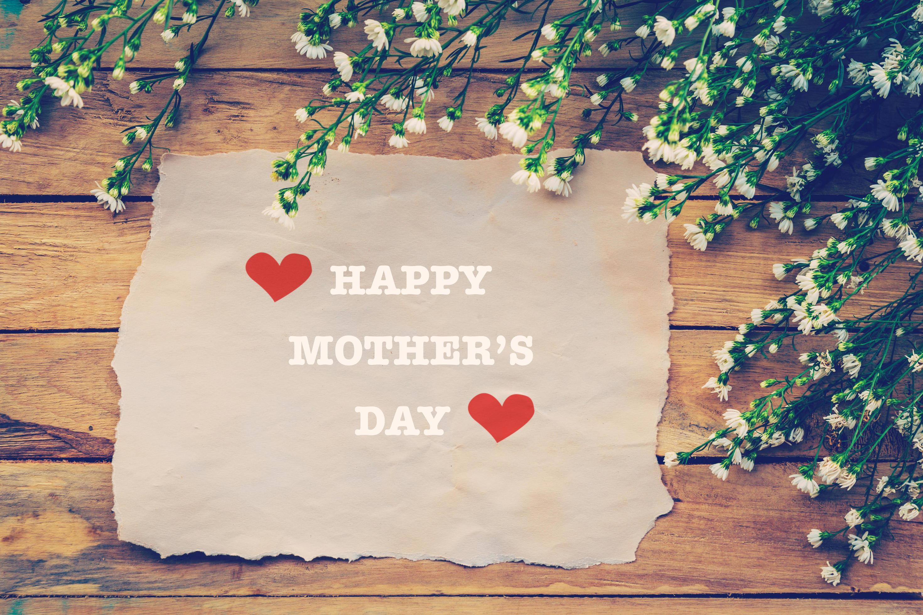 Happy Mothers day on brown paper with white flower on wooden board Stock Free