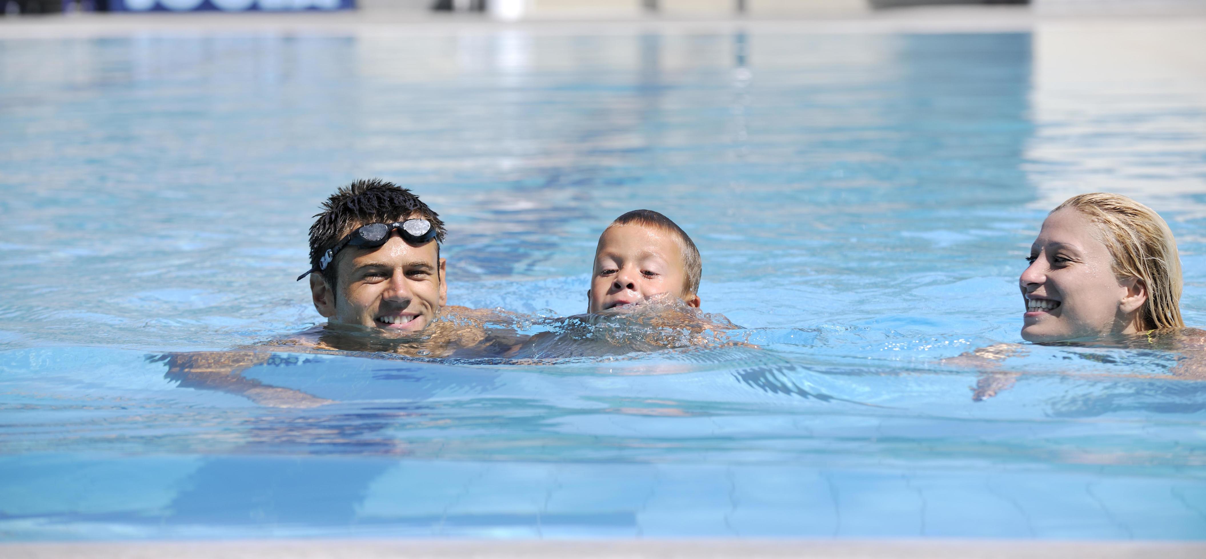 happy young family have fun on swimming pool Stock Free