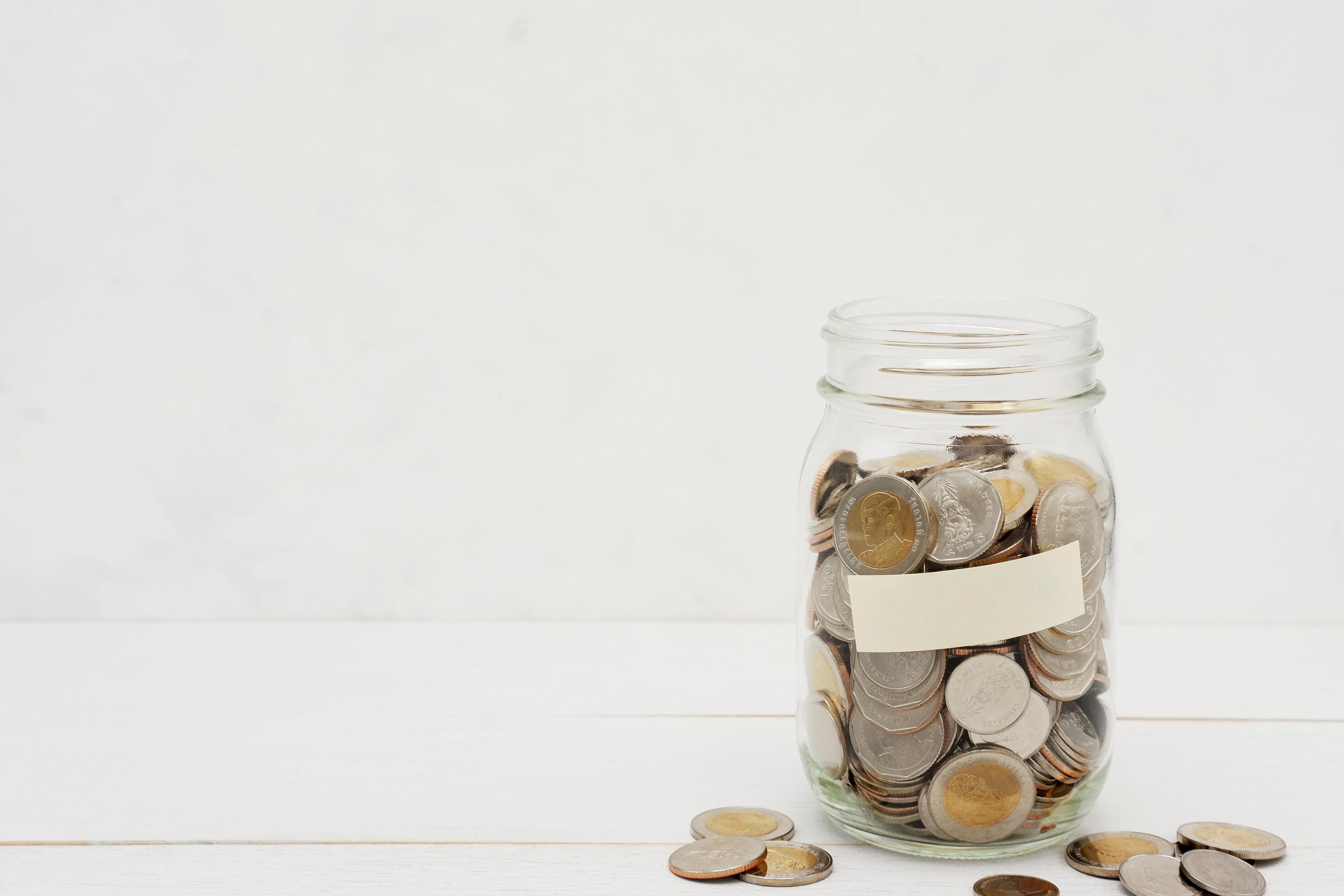 Thai Baht coins in a glass jar. Business and finance concept. Stock Free