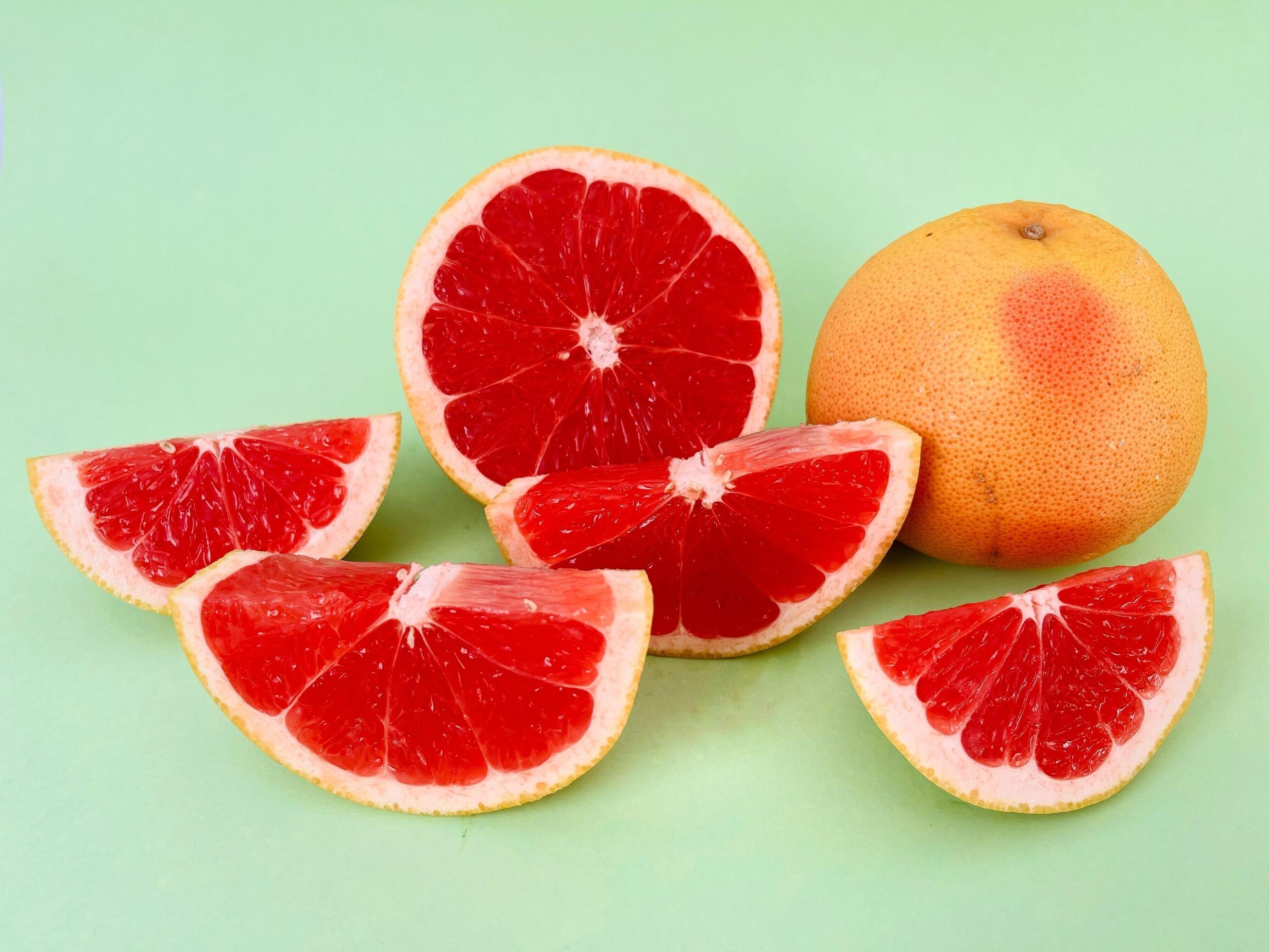 Fresh grapefruit fruit. Grapefruit isolated on green background. Grapefruit with clipping path. Stock Free