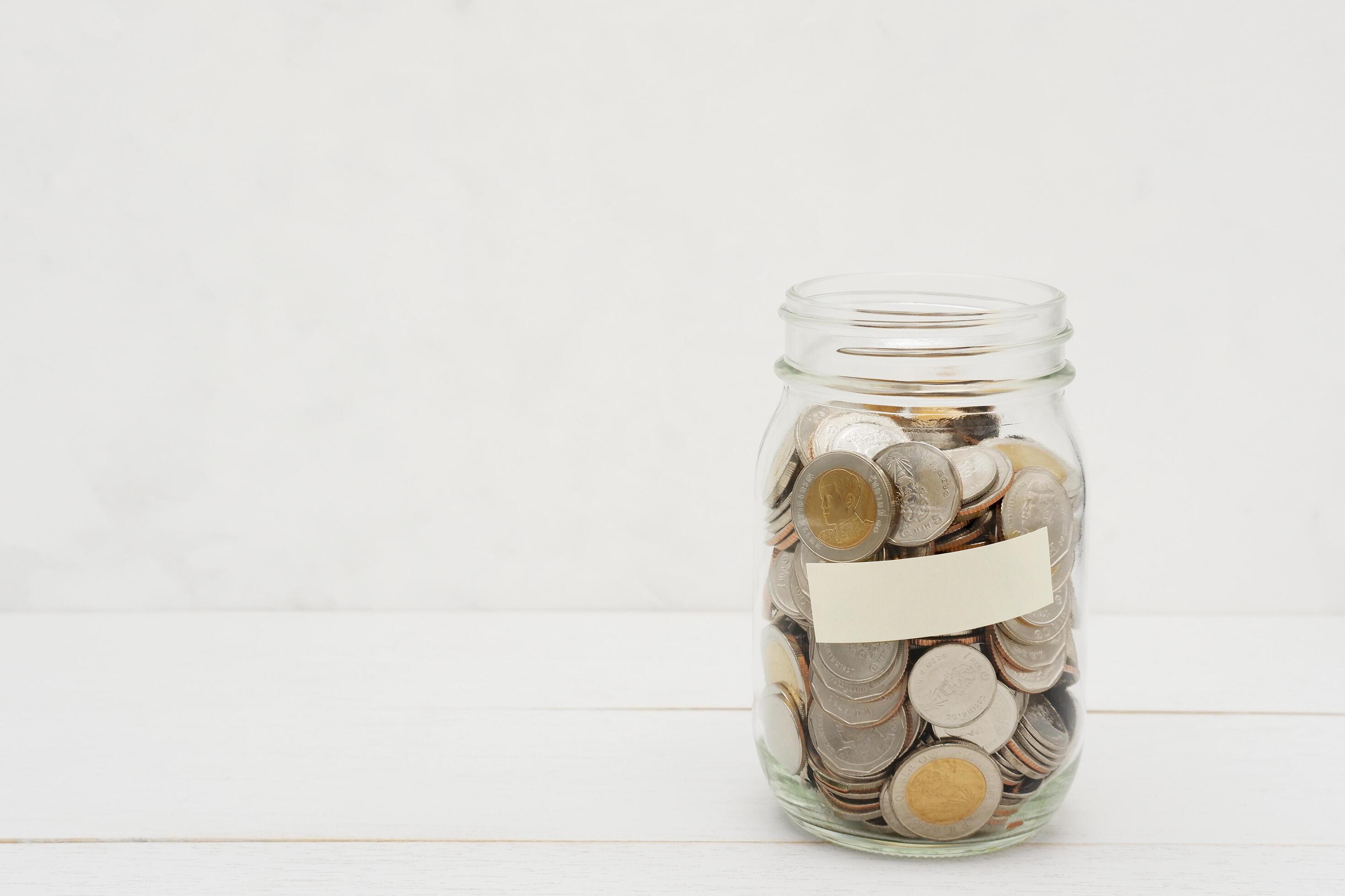 Thai Baht coins in a glass jar. Business and finance concept. Stock Free