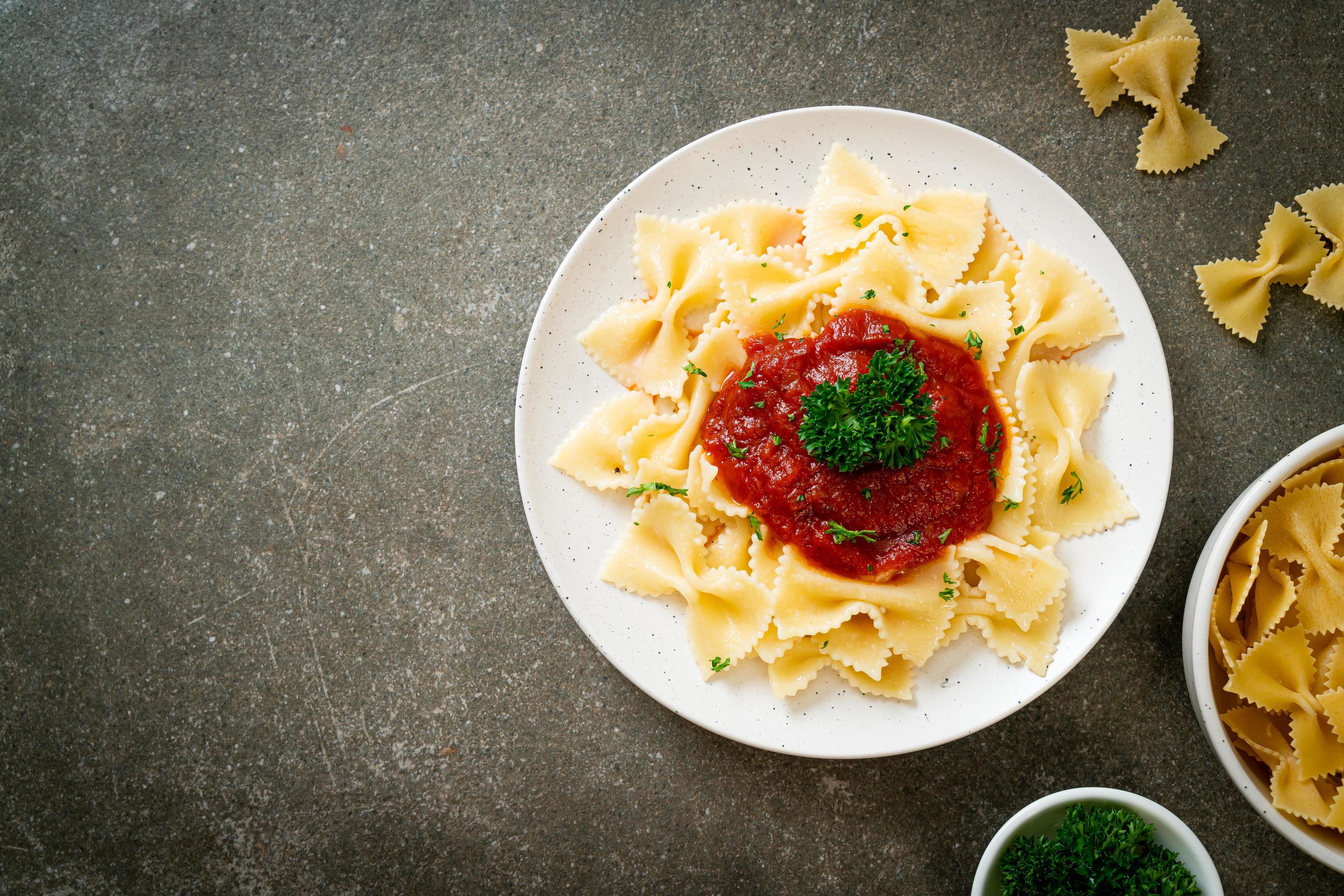 Farfalle pasta in tomato sauce with parsley – Italian food style Stock Free