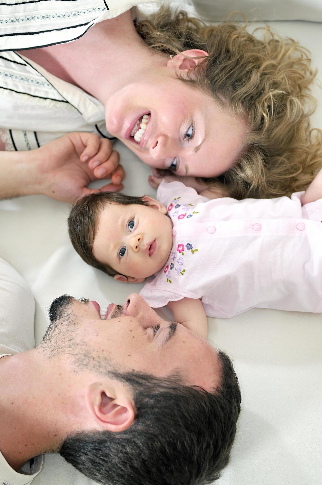 indoor portrait with happy young family and cute little babbybe Stock Free