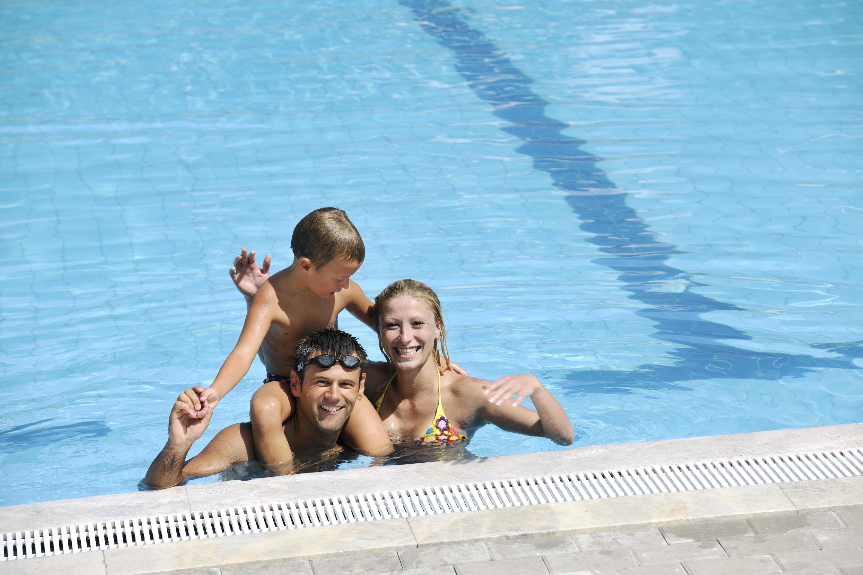 happy young family have fun on swimming pool Stock Free