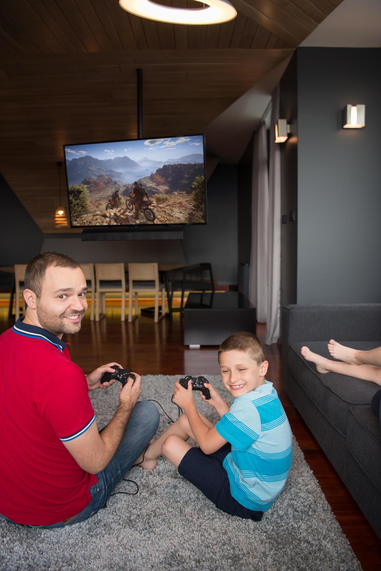 
									Happy family playing a motocross video game Stock Free