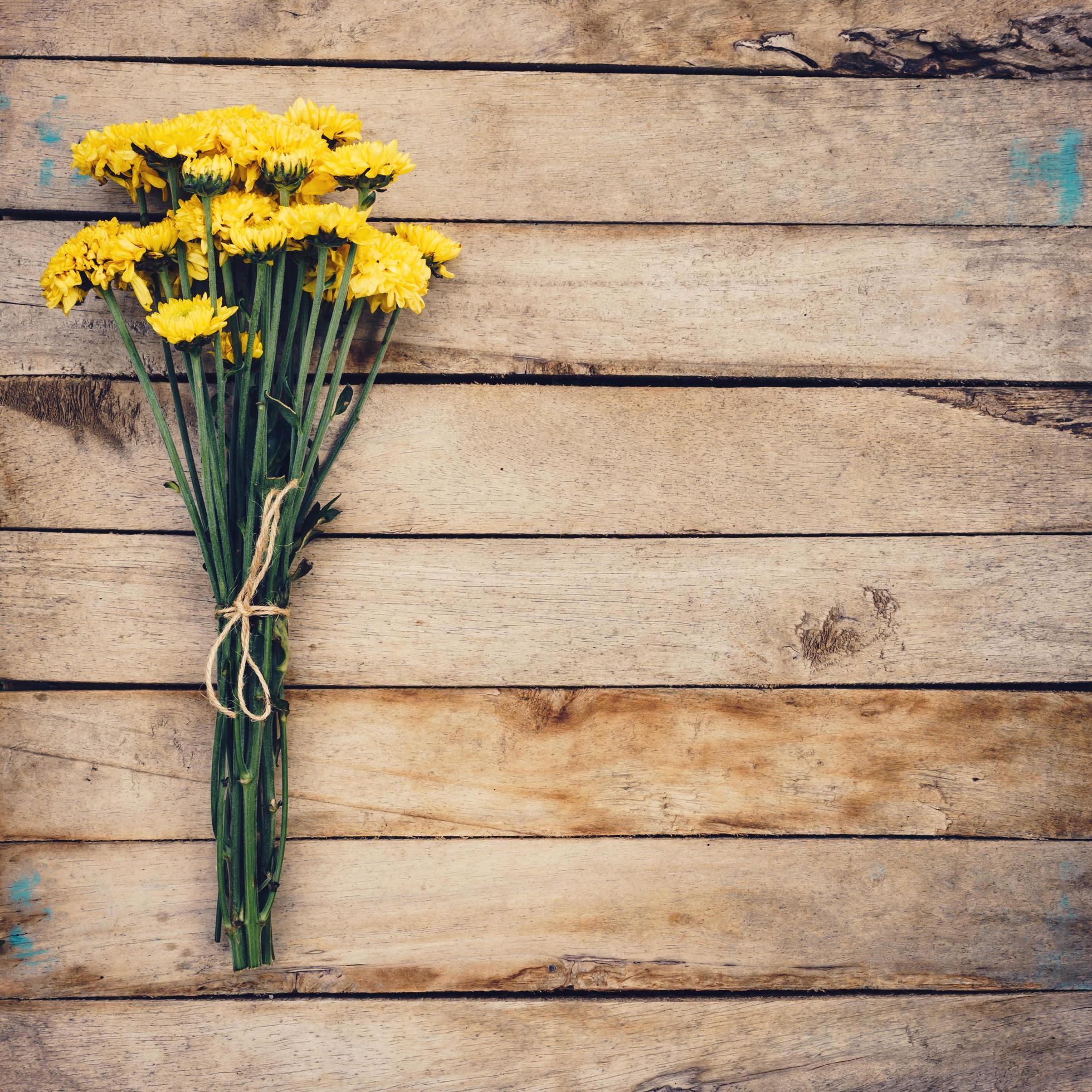 Yellow flowers of bouquet, top view on wooden background texture with copy space Stock Free