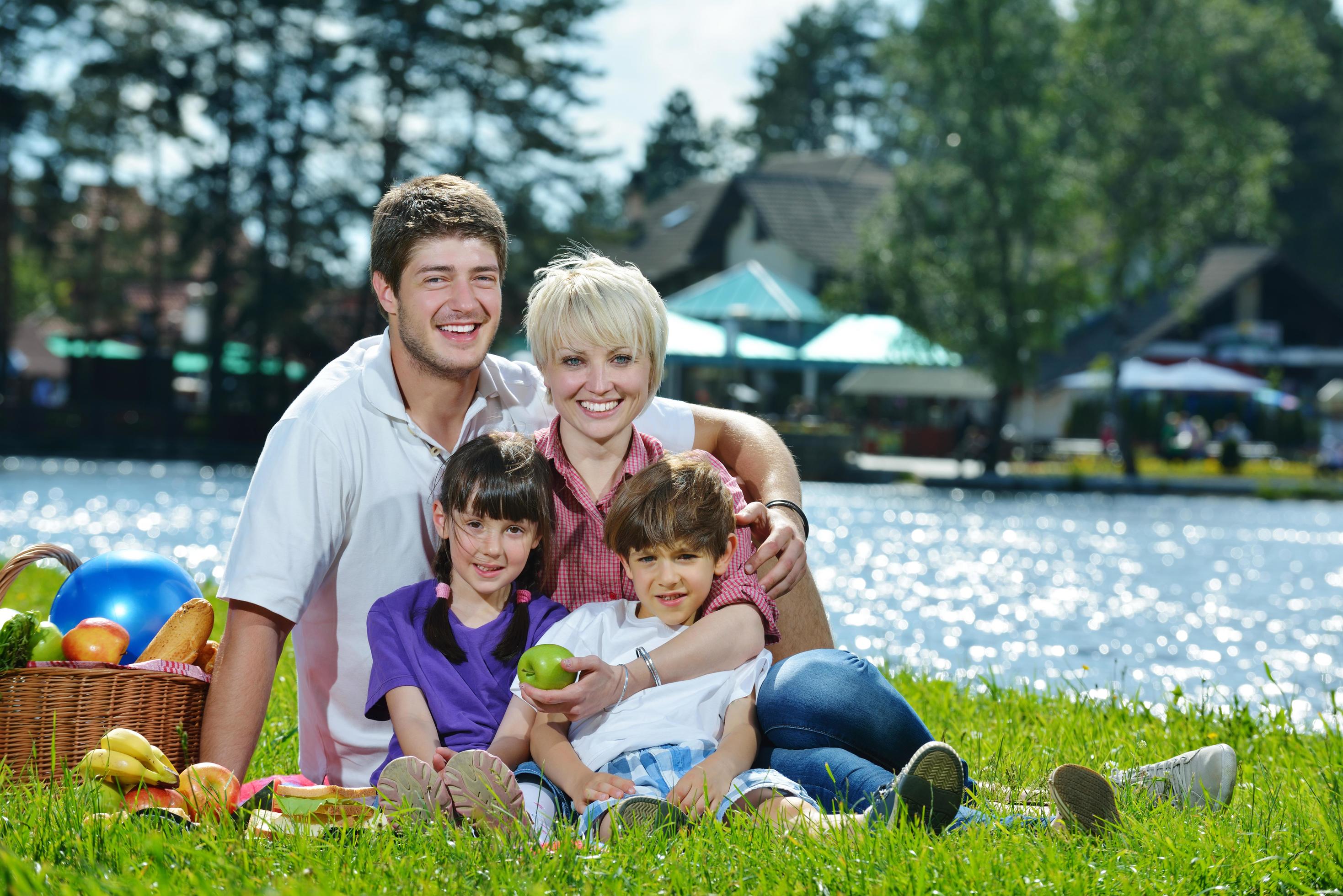 Happy family playing together in a picnic outdoors Stock Free