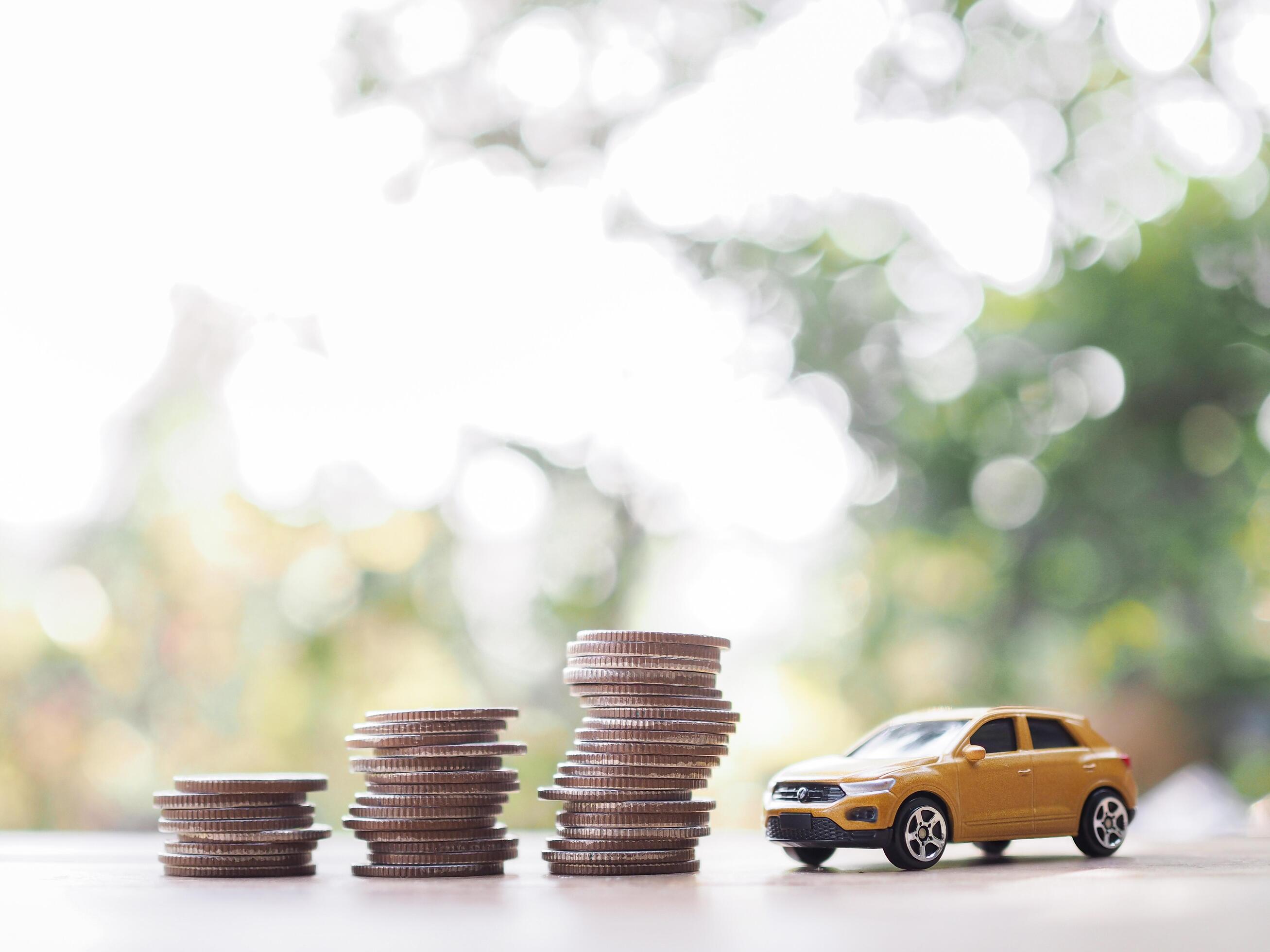 Toy car and stack of coins. The concept of saving money and manage to success transport business Stock Free