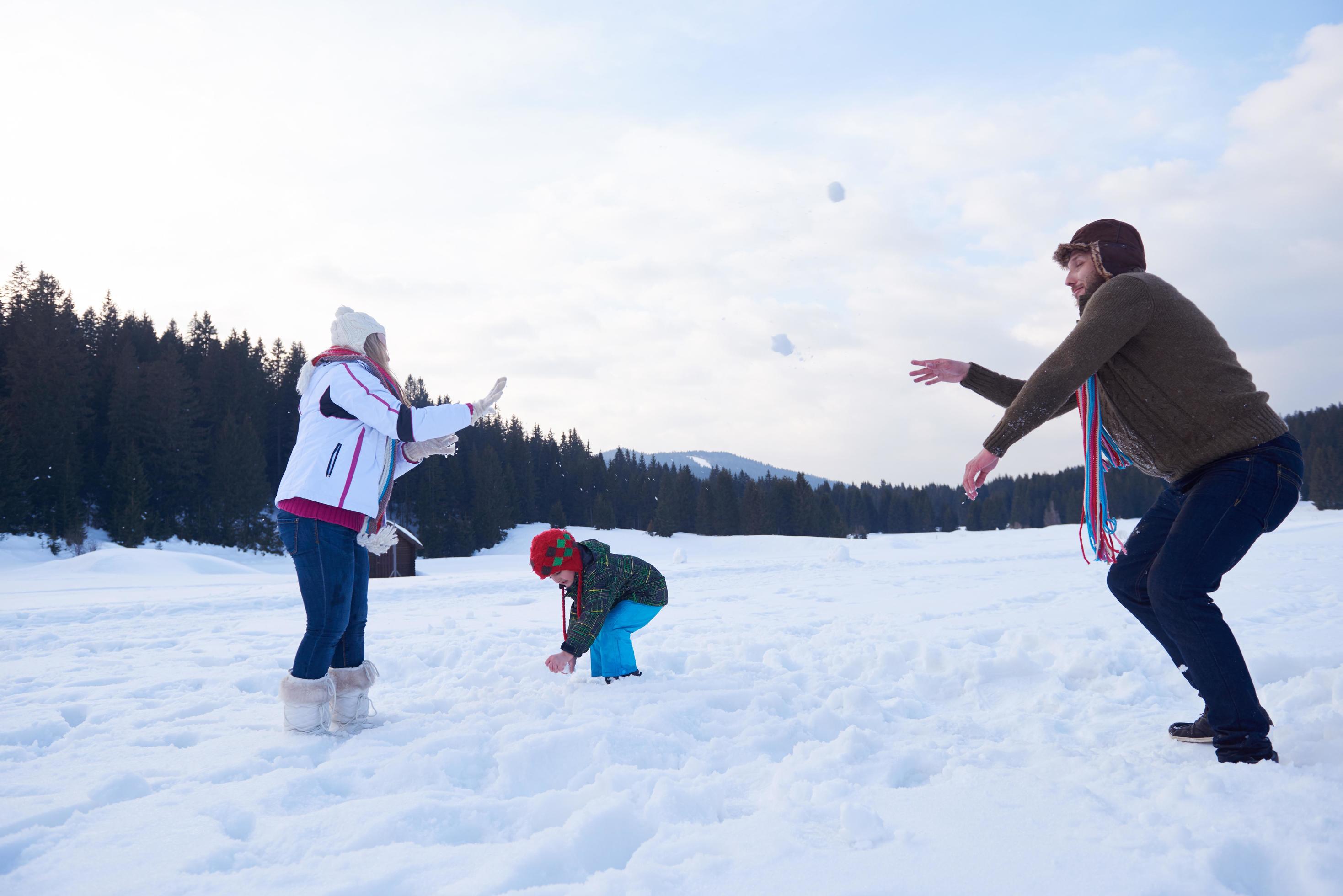 happy family playing together in snow at winter Stock Free