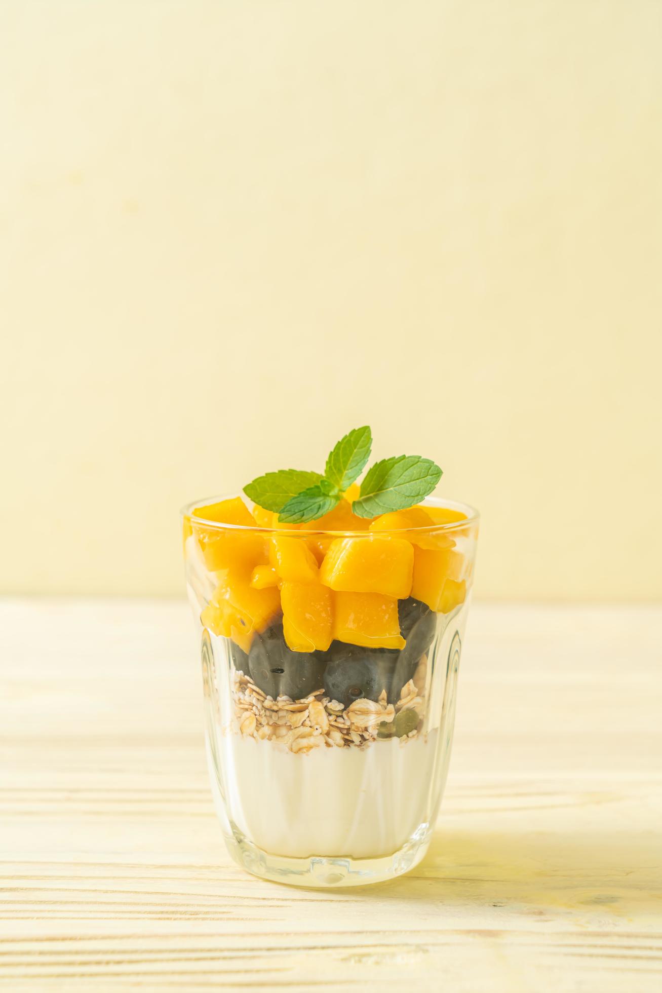 Homemade fresh mango and fresh blueberry with yogurt and granola – healthy food style Stock Free