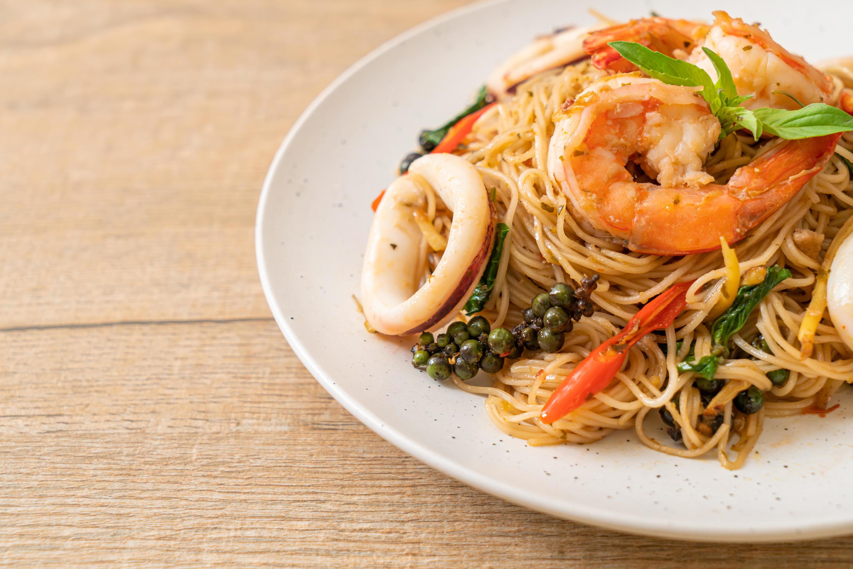 Stir-fried Chinese noodle with basil, chili, shrimps and squid – Asian food style Stock Free