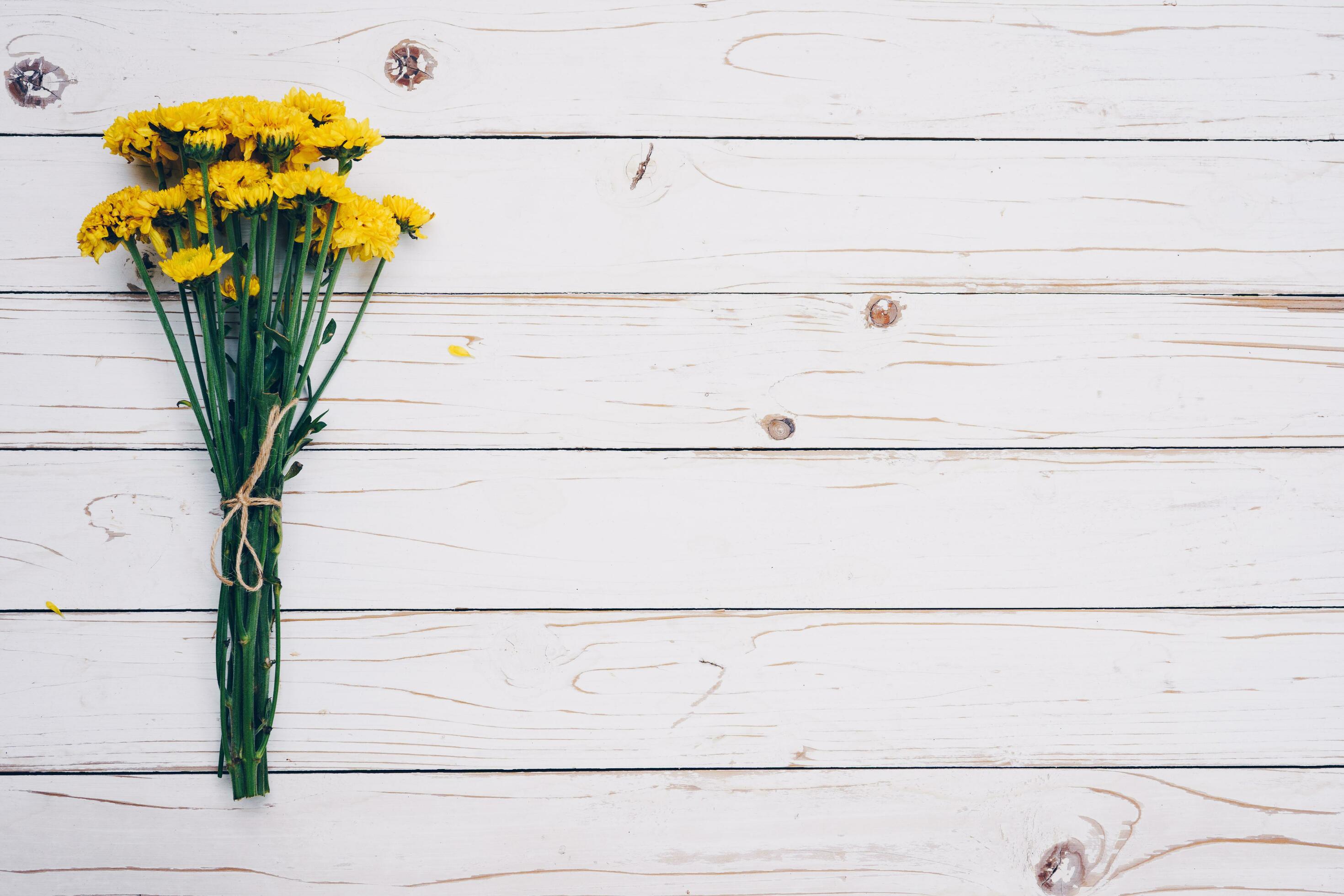 Yellow flowers of bouquet, top view on white wooden background texture with copy space Stock Free