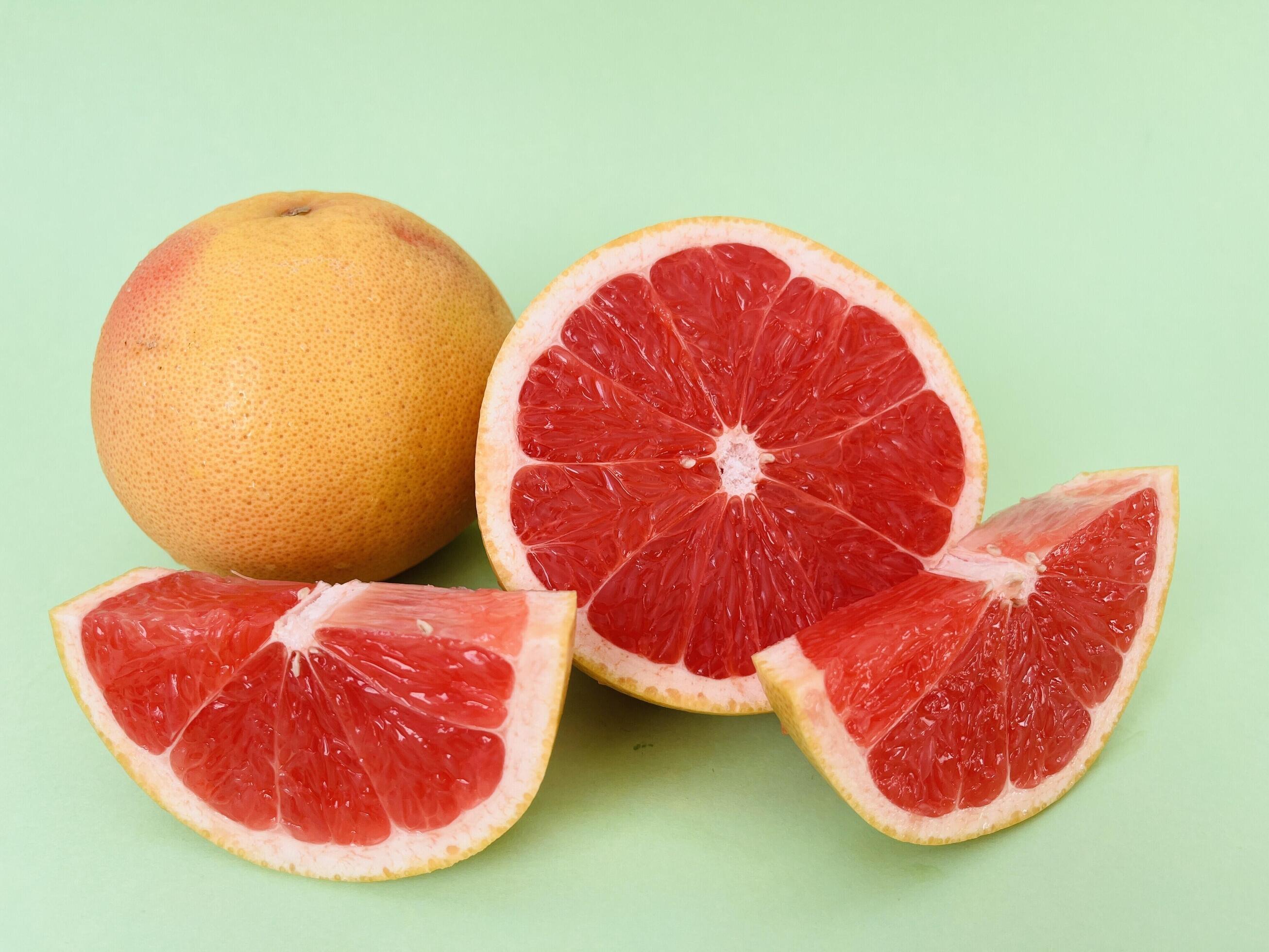 Fresh grapefruit fruit. Grapefruit isolated on green background. Grapefruit with clipping path. Stock Free