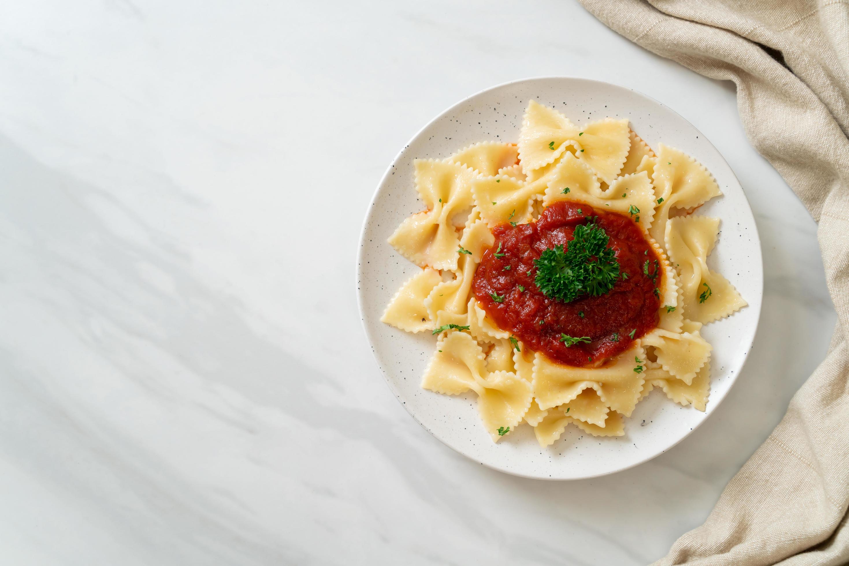 Farfalle pasta in tomato sauce with parsley – Italian food style Stock Free