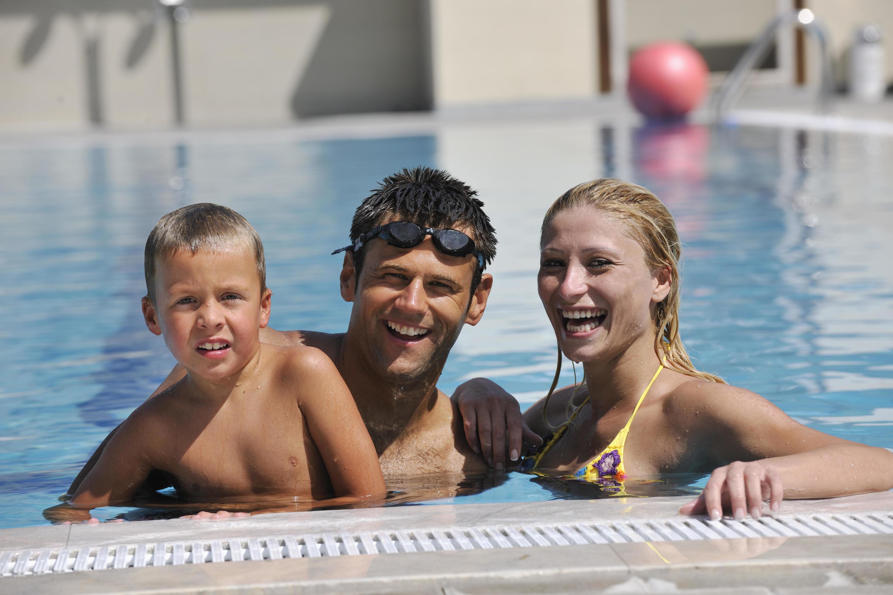 happy young family have fun on swimming pool Stock Free