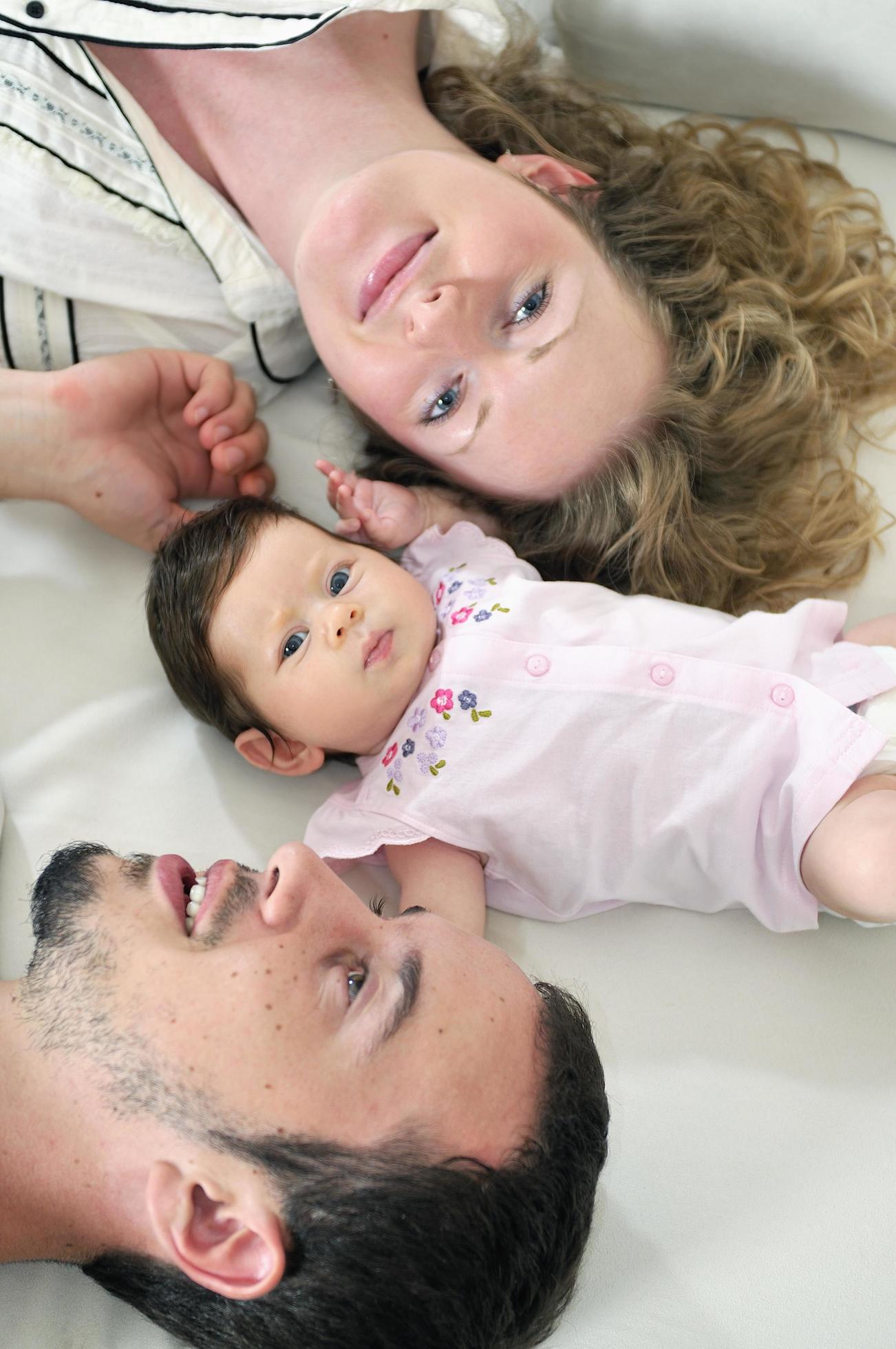 indoor portrait with happy young family and cute little babby Stock Free